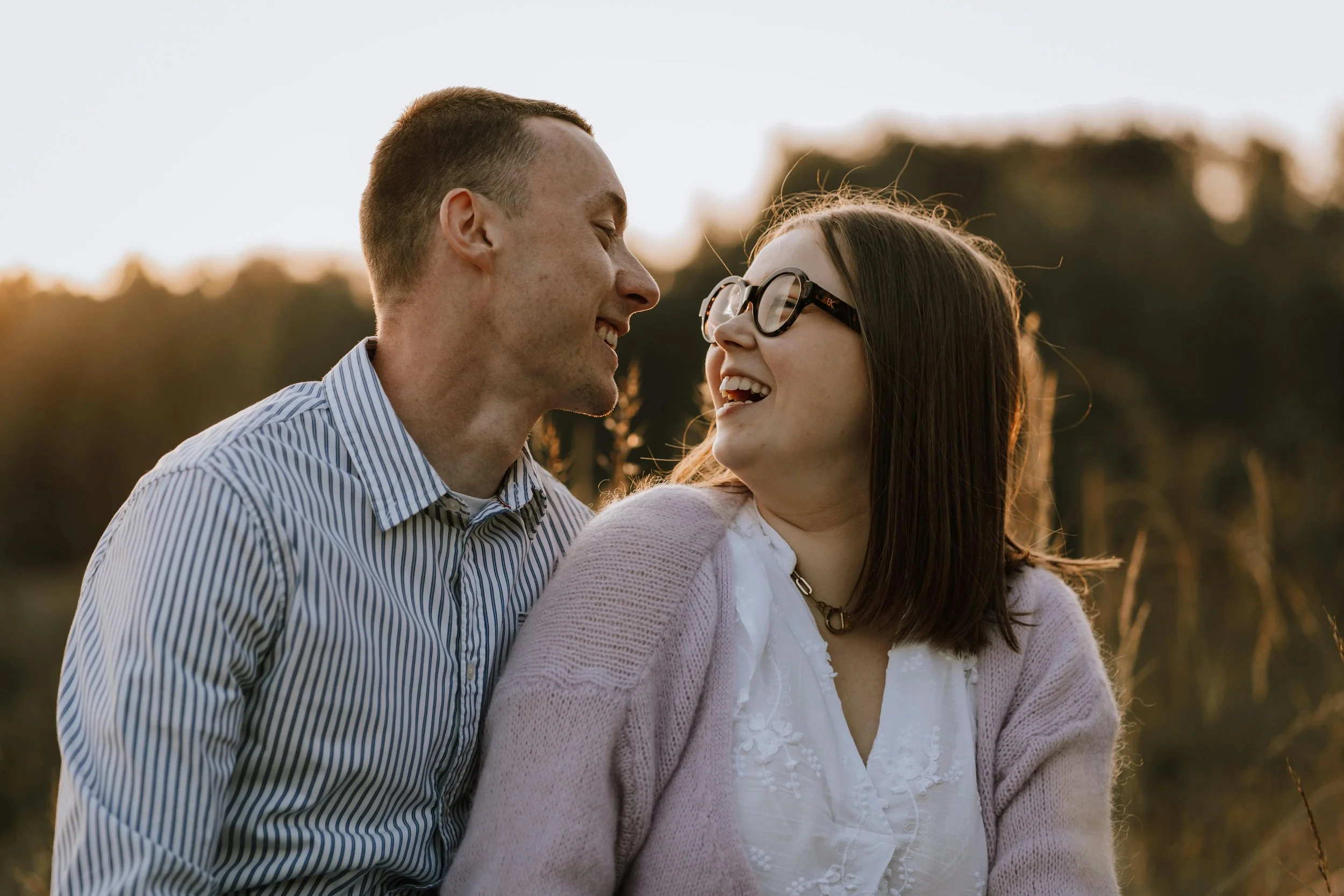 A happy couple standing in a field and looking at each other, representing renewed love and deep connection in a relationship.