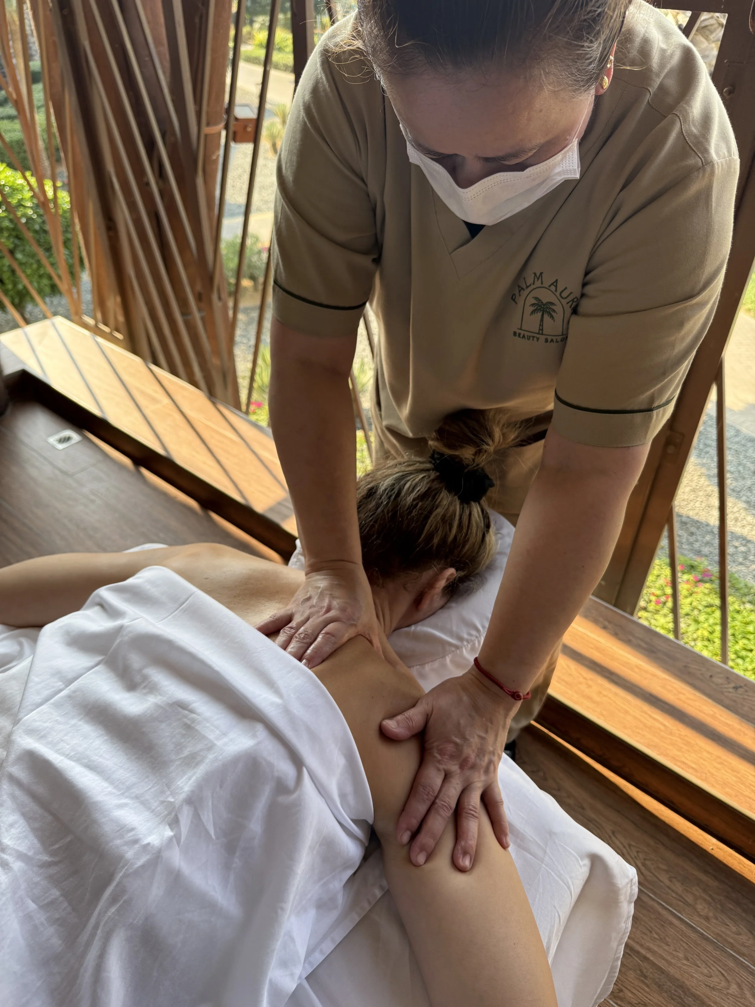 lady doing deep tissue massage on a massage bed in calm surroundings