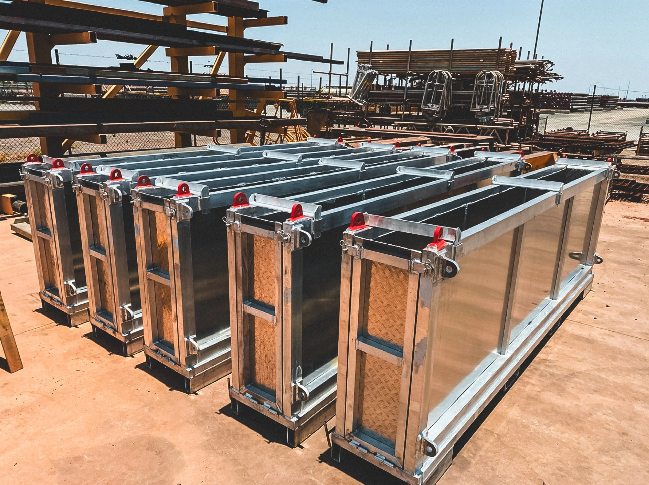 Stacked metal scaffolding or support structures at a construction site under clear sky.