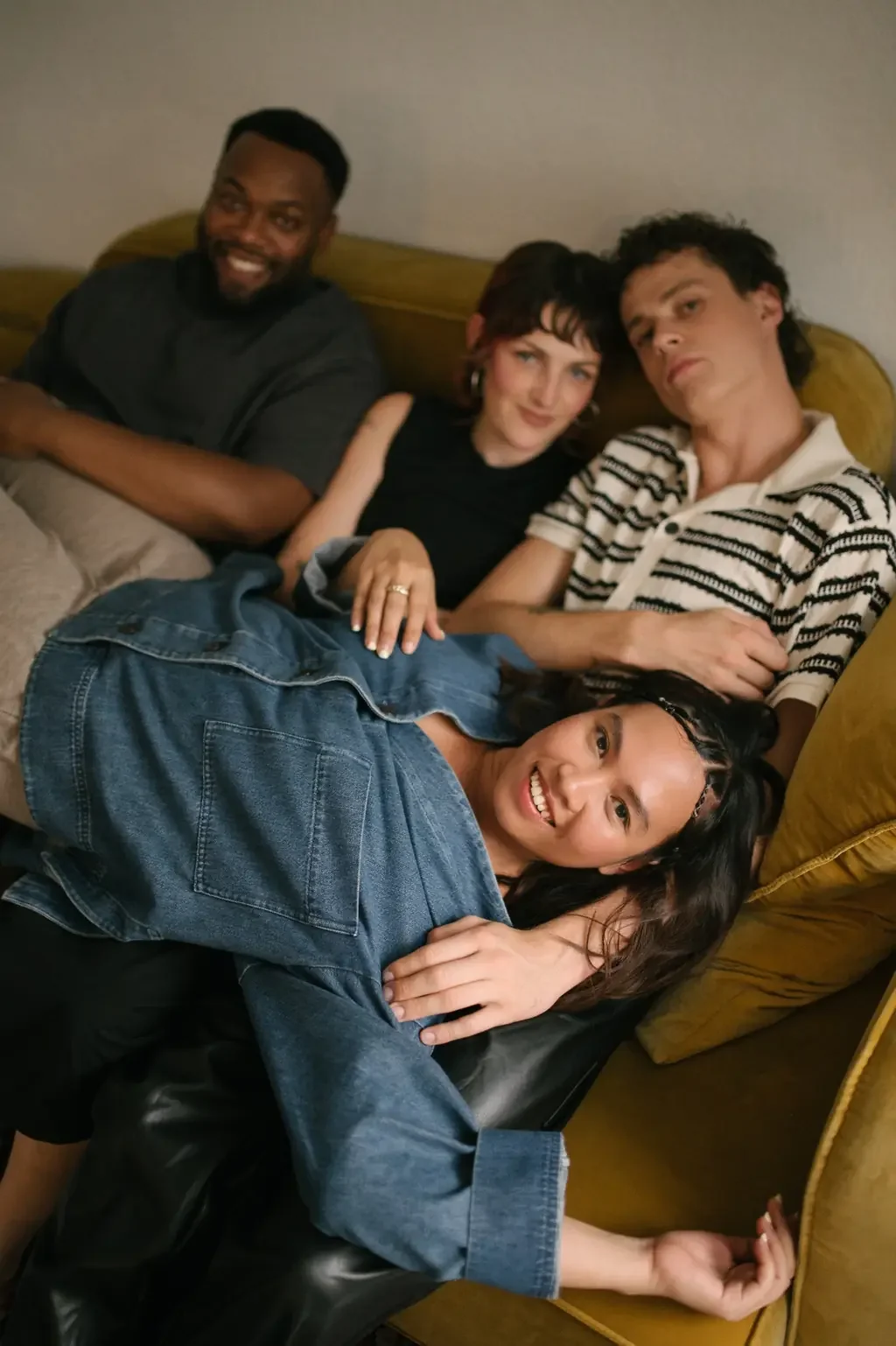 Four friends piled together on a couch, the kind of easy neurodivergent friendships adults with ADHD are searching for.