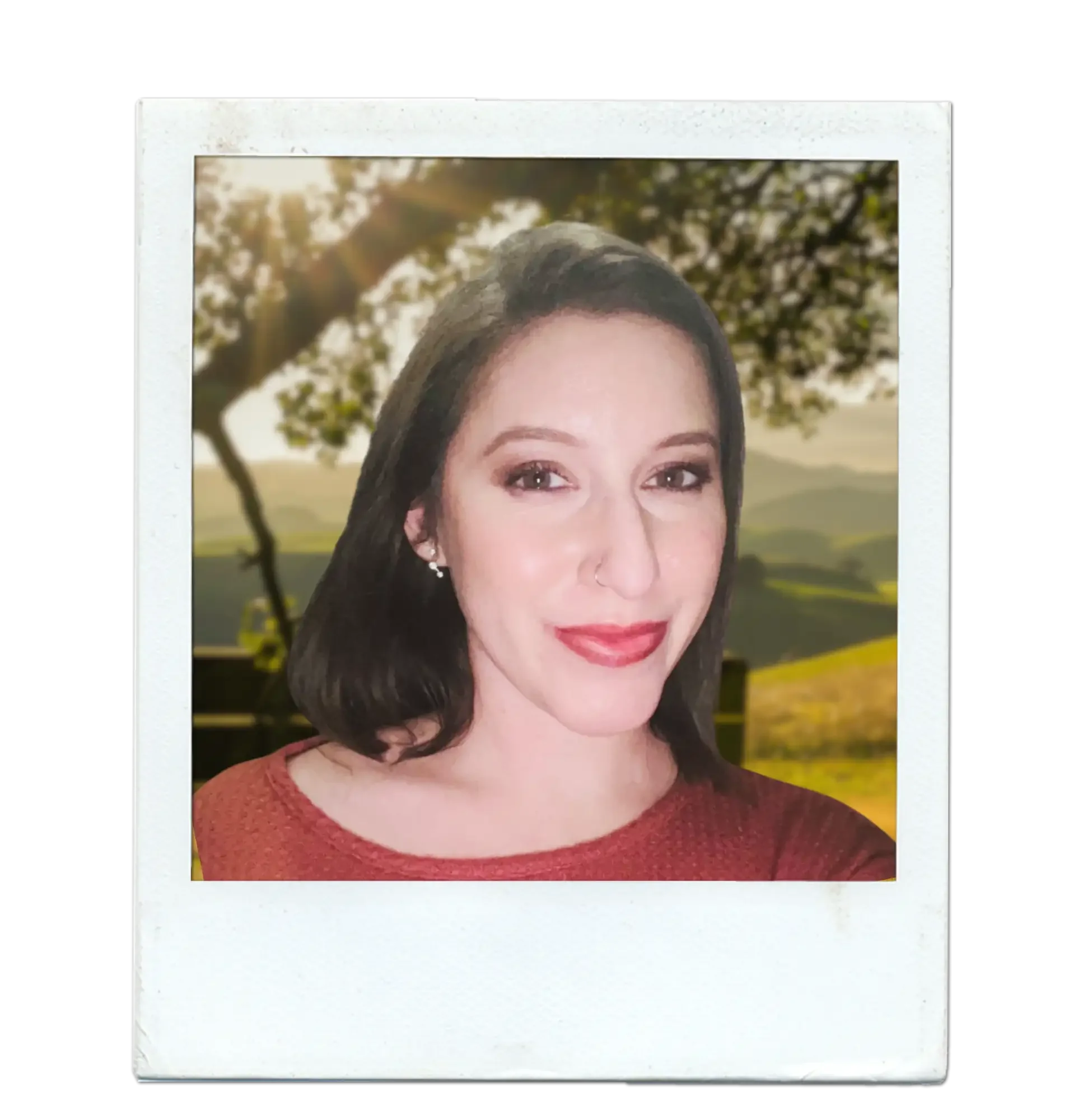 A woman with shoulder-length dark hair, wearing a red top, smiling, with a background of a landscape featuring trees, hills, and sunlight.