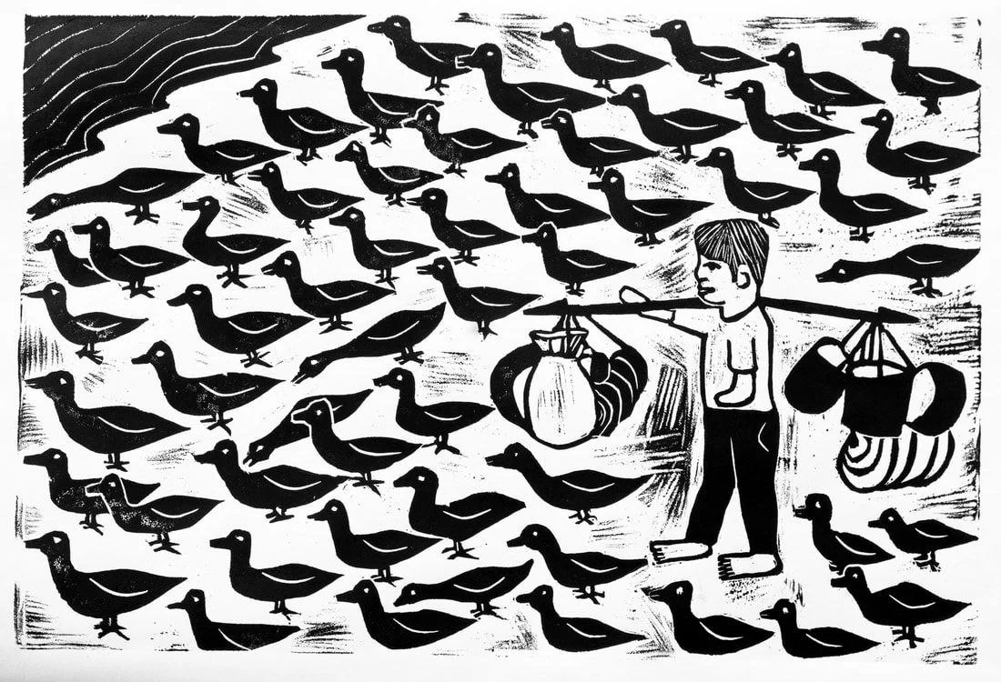 A young boy is feeding ducks in a pond, carrying bags and containers, with numerous ducks swimming around him.