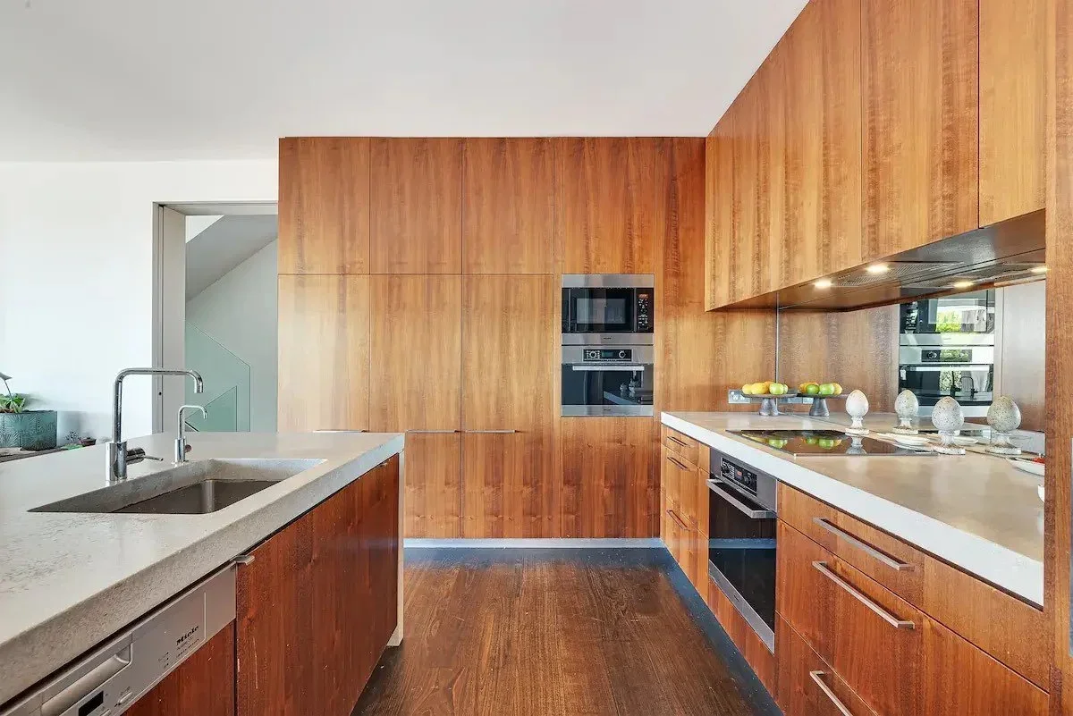 Modern kitchen with wooden cabinets, white countertops, built-in microwave, oven, and stovetop with egg decorations