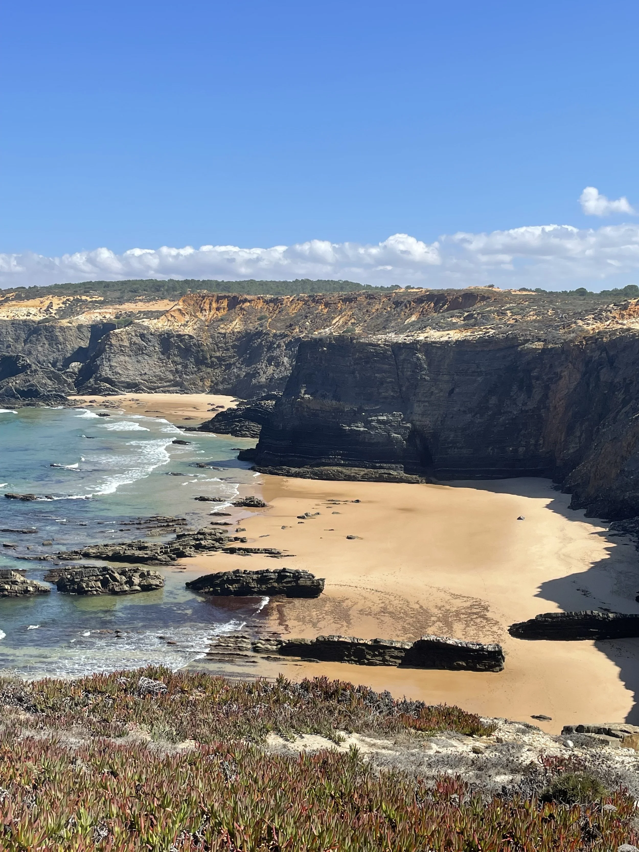 A scenic view of a sandy beach with cliffs and rocks, overlooking the ocean on a clear day with blue sky and some clouds.
Enjoy a floral retreat in Portugal, near to Lisbon, in Cavaleiro, Monte Meu. Workshops with VIVKO STUDIO.