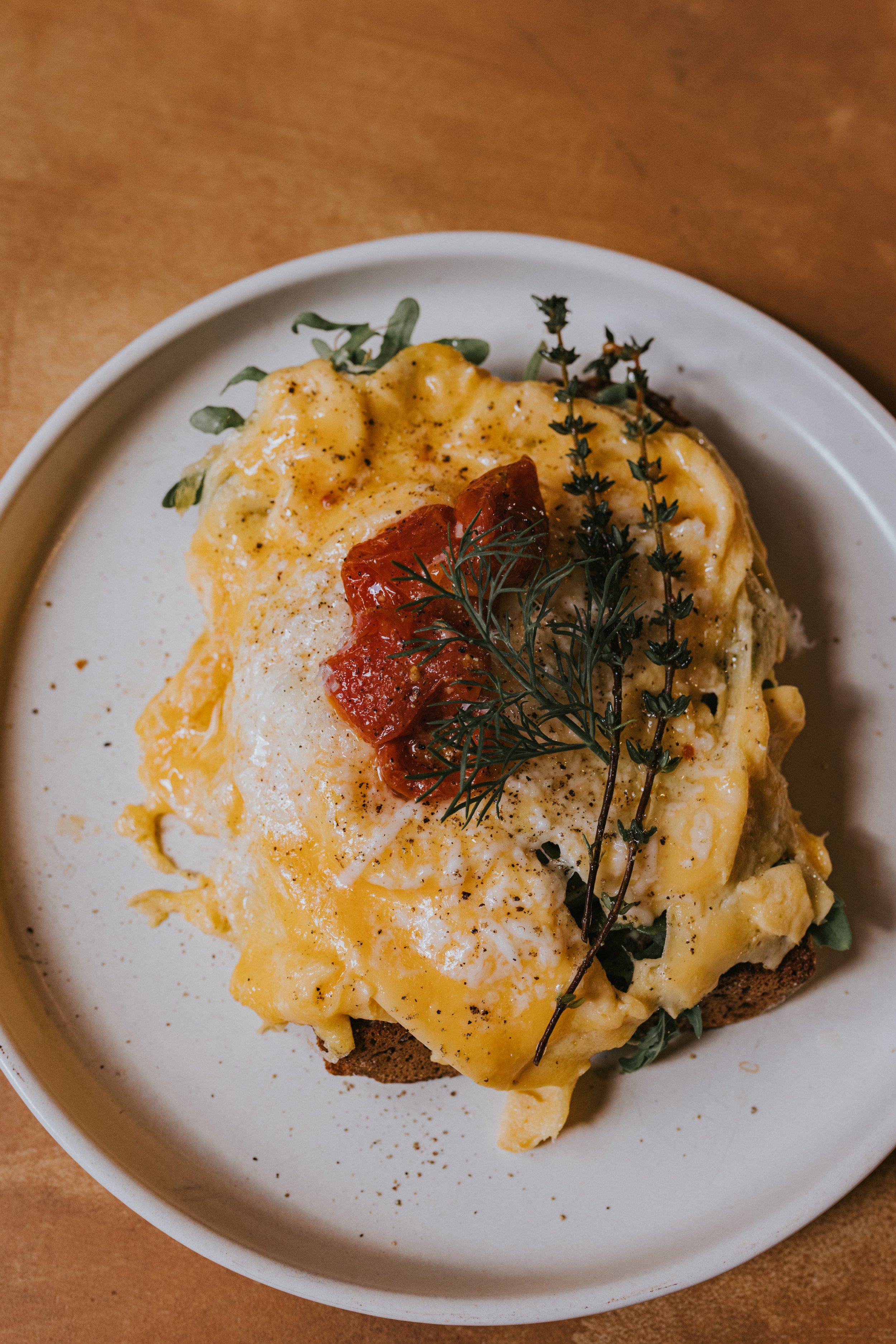 Delicious Eggs served on a white plate with garnished herbs, and seasoning.