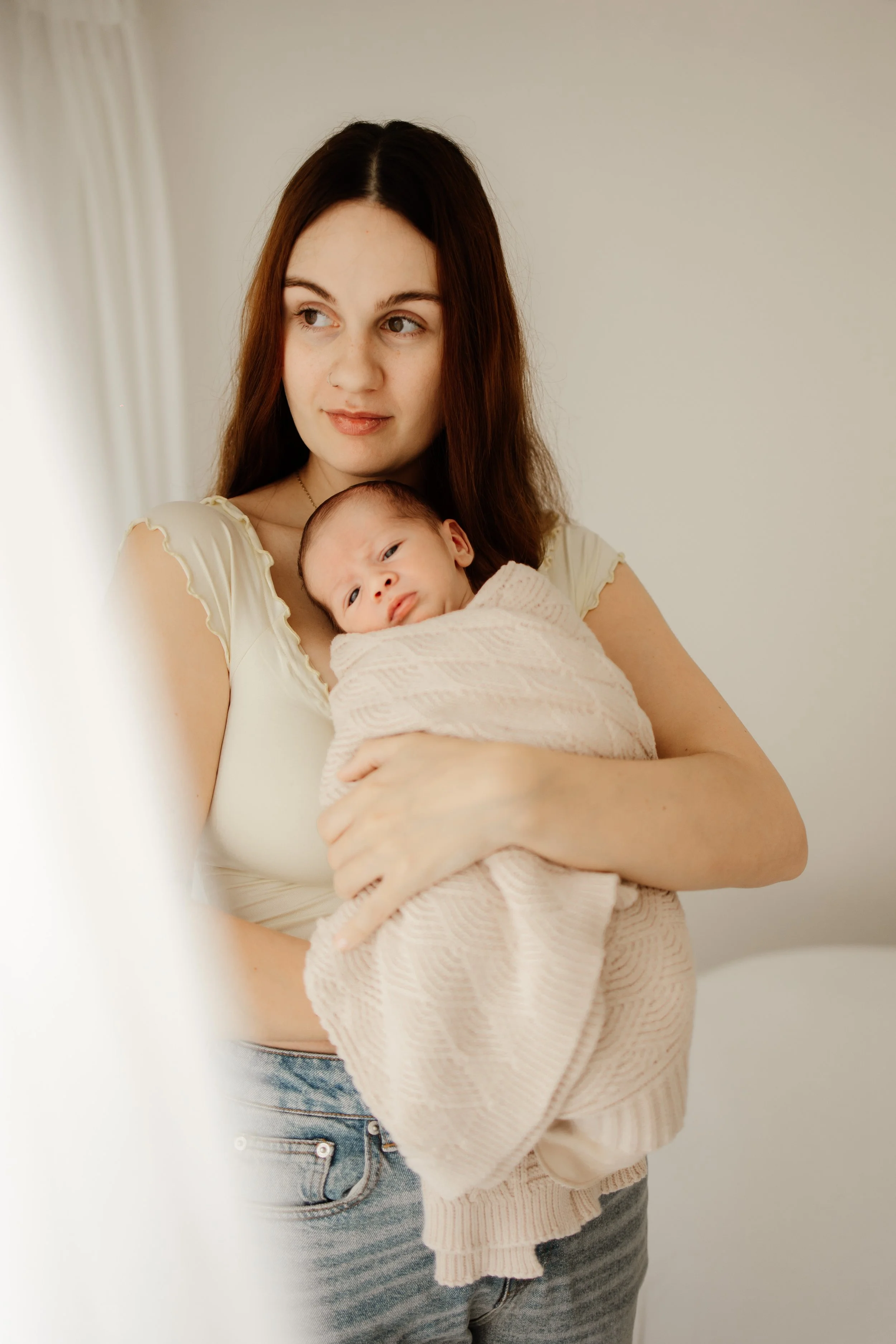 Mum holding newborn during relaxed photoshoot in Lanarkshire studio