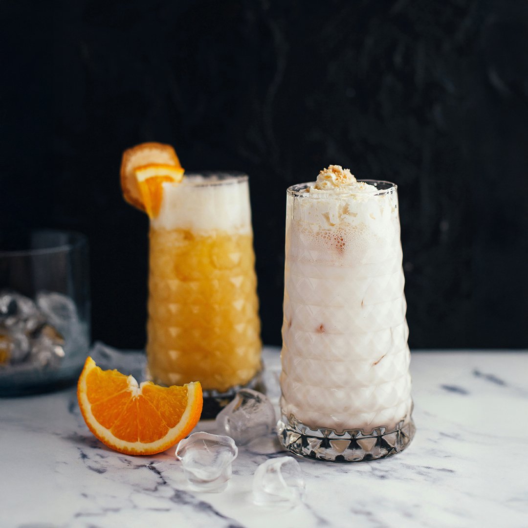 Two frozen cocktails on a marble bench
