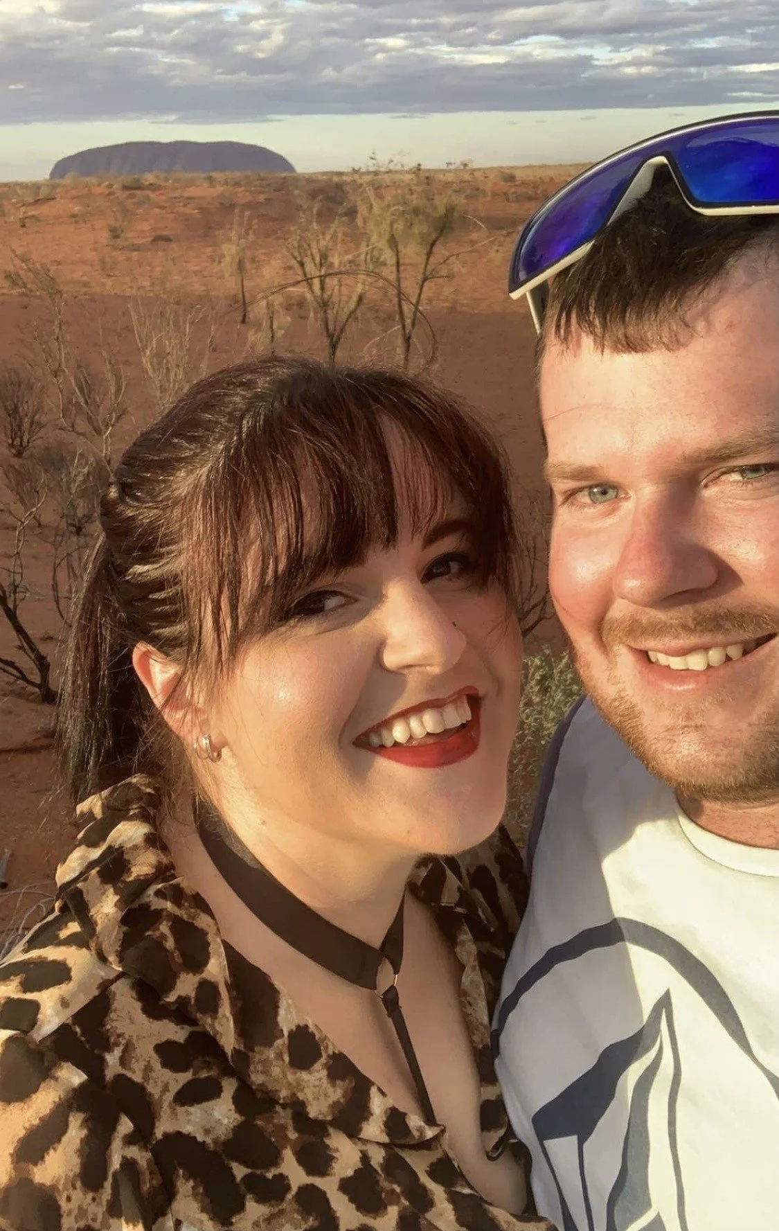 A photo of Hayden and Cathy the owners of Smoke It Mackay in front of Uluru