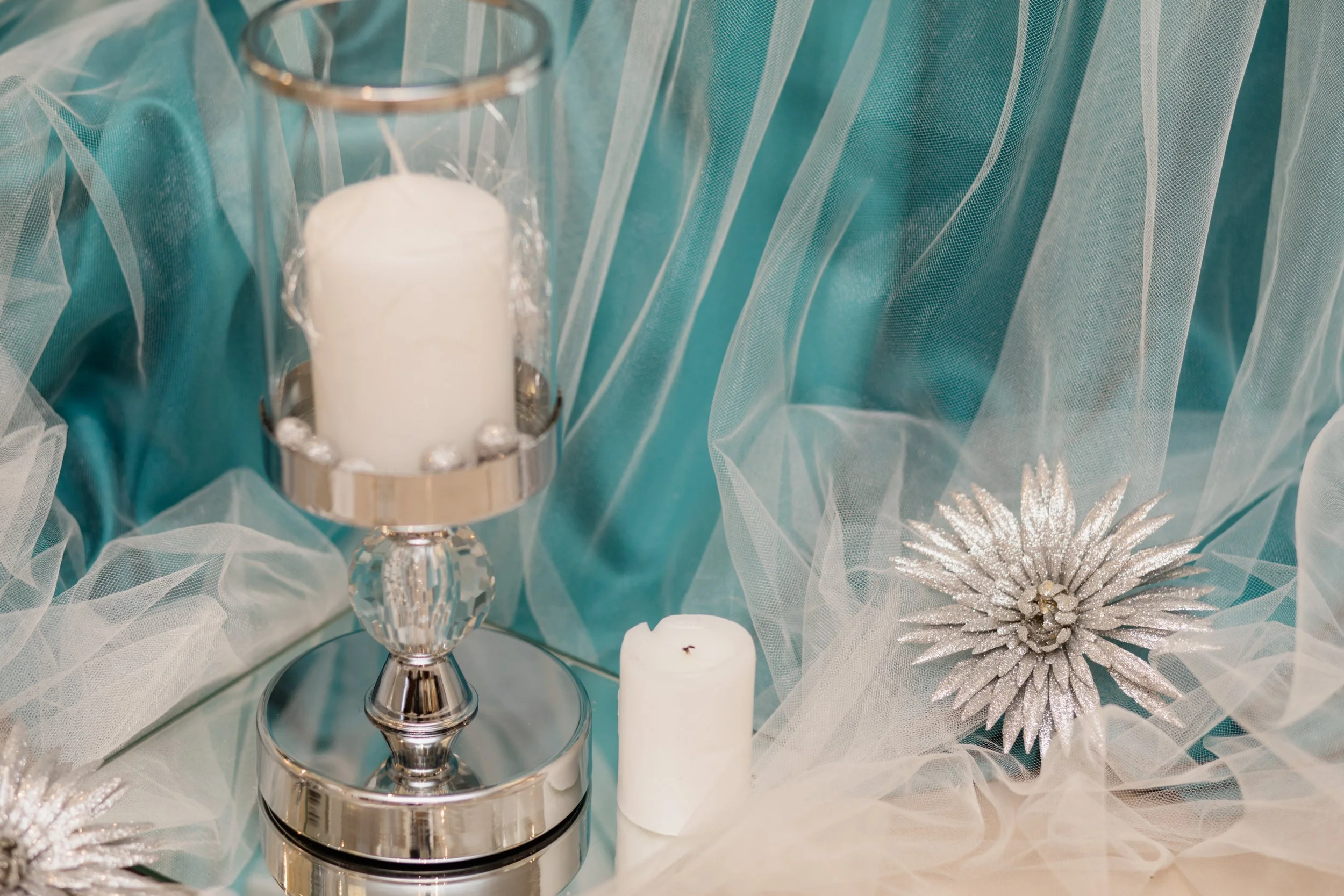 white-candle-glass-candlestick-with-decorative-aquamarine-silk.jpg