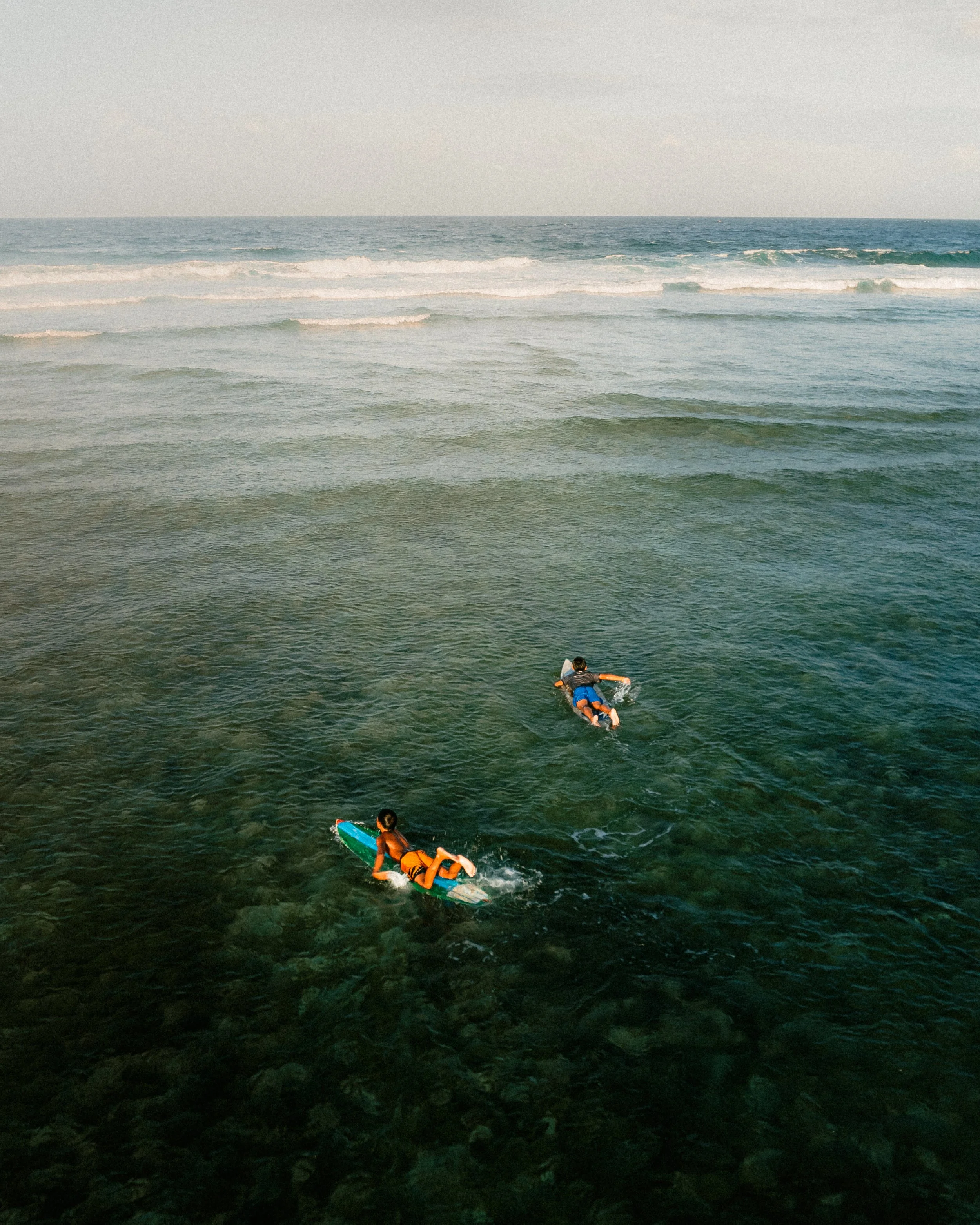 Beutiful photo of surfers surfing in the green and blue ocean
