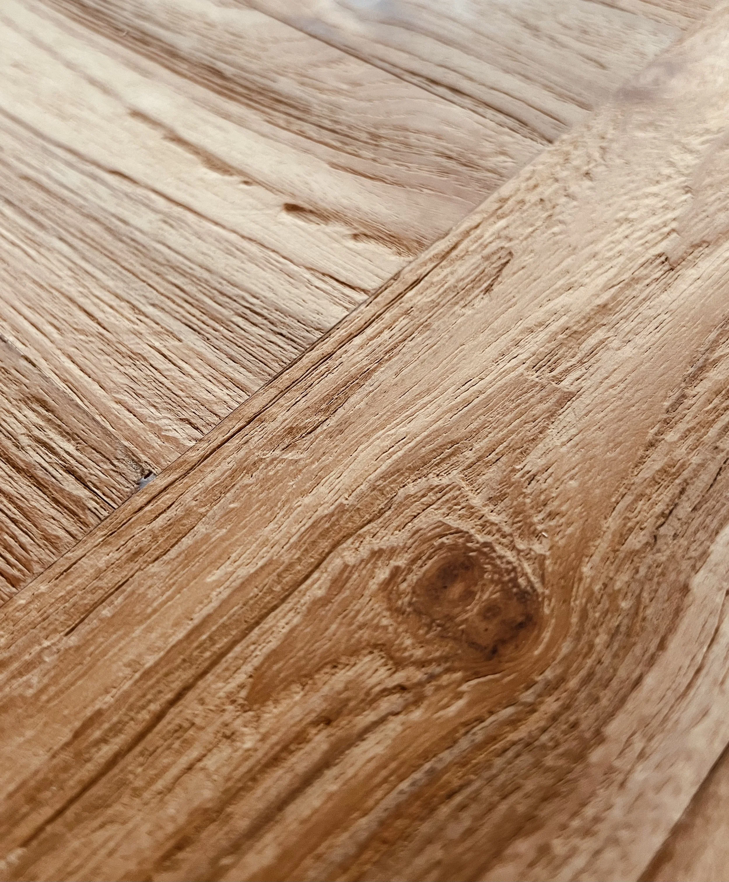 Nahaufnahme von massiven, naturbelassenen Holzbrettern mit sichtbarer Maserung und Textur.
