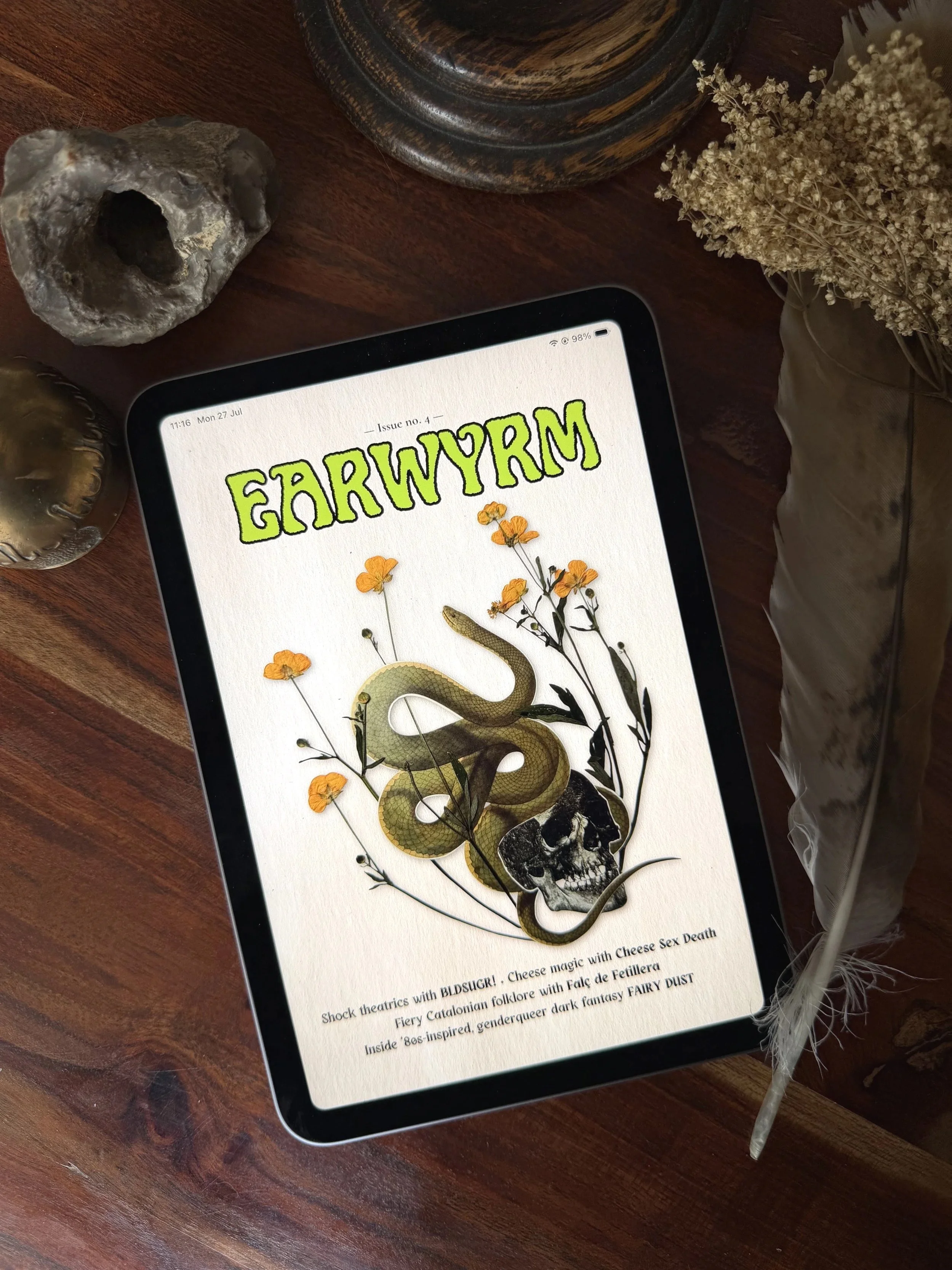 top down shot of a wooden table with issue 4 of the zine on an ipad