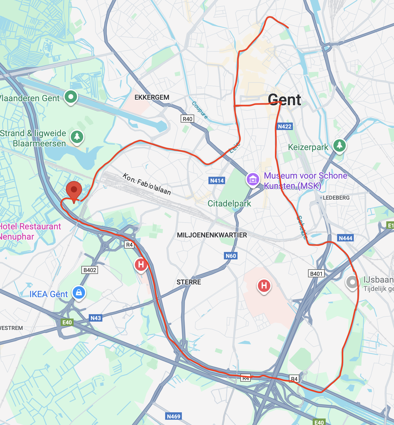 Een stadsplattegrond van Gent met een rode route die door de stad loopt, inclusief kenmerken zoals stations, parken, en hotels.