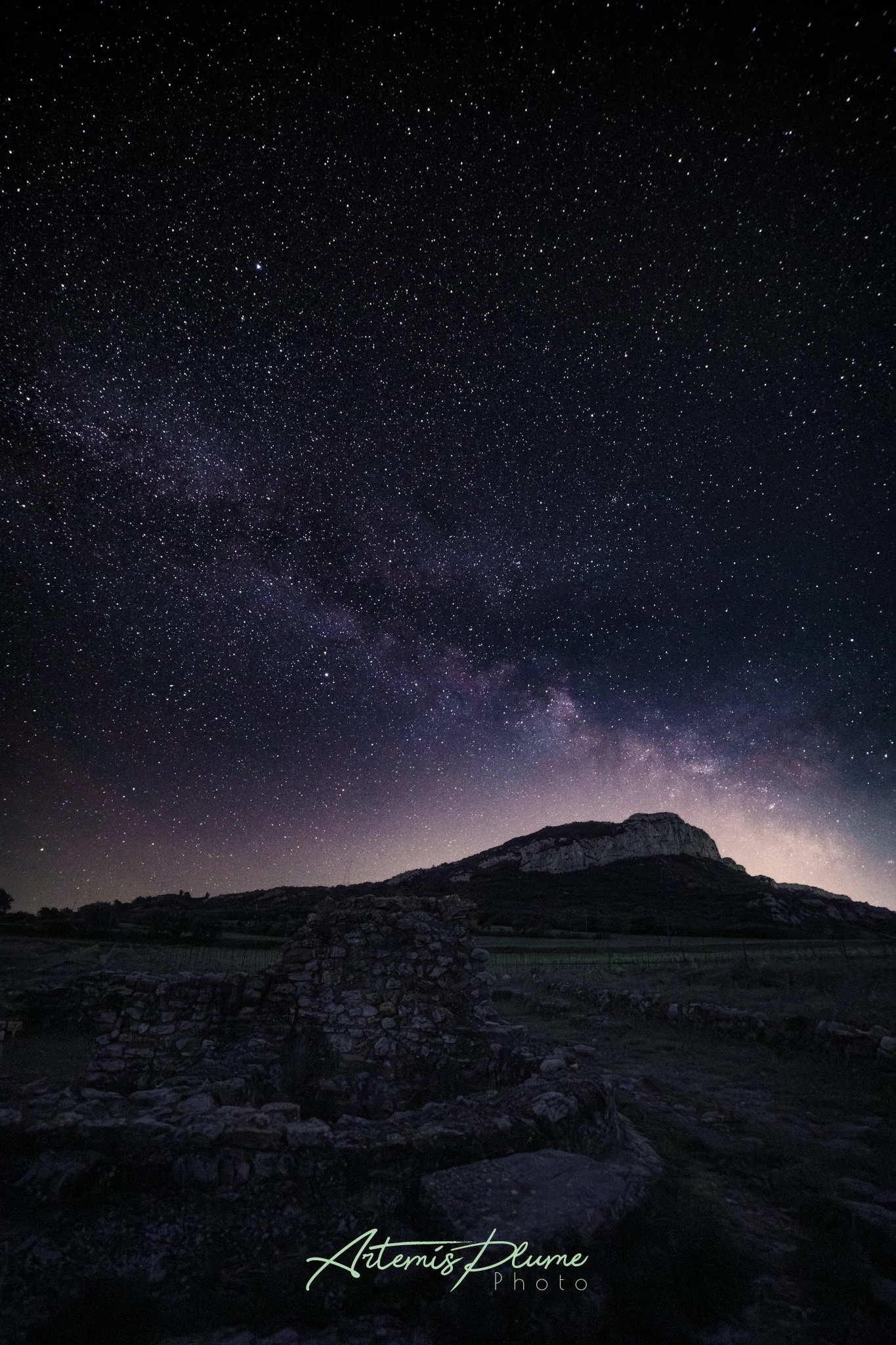 Photo de la voie lactée au dessus d'une ruine et d'une coline