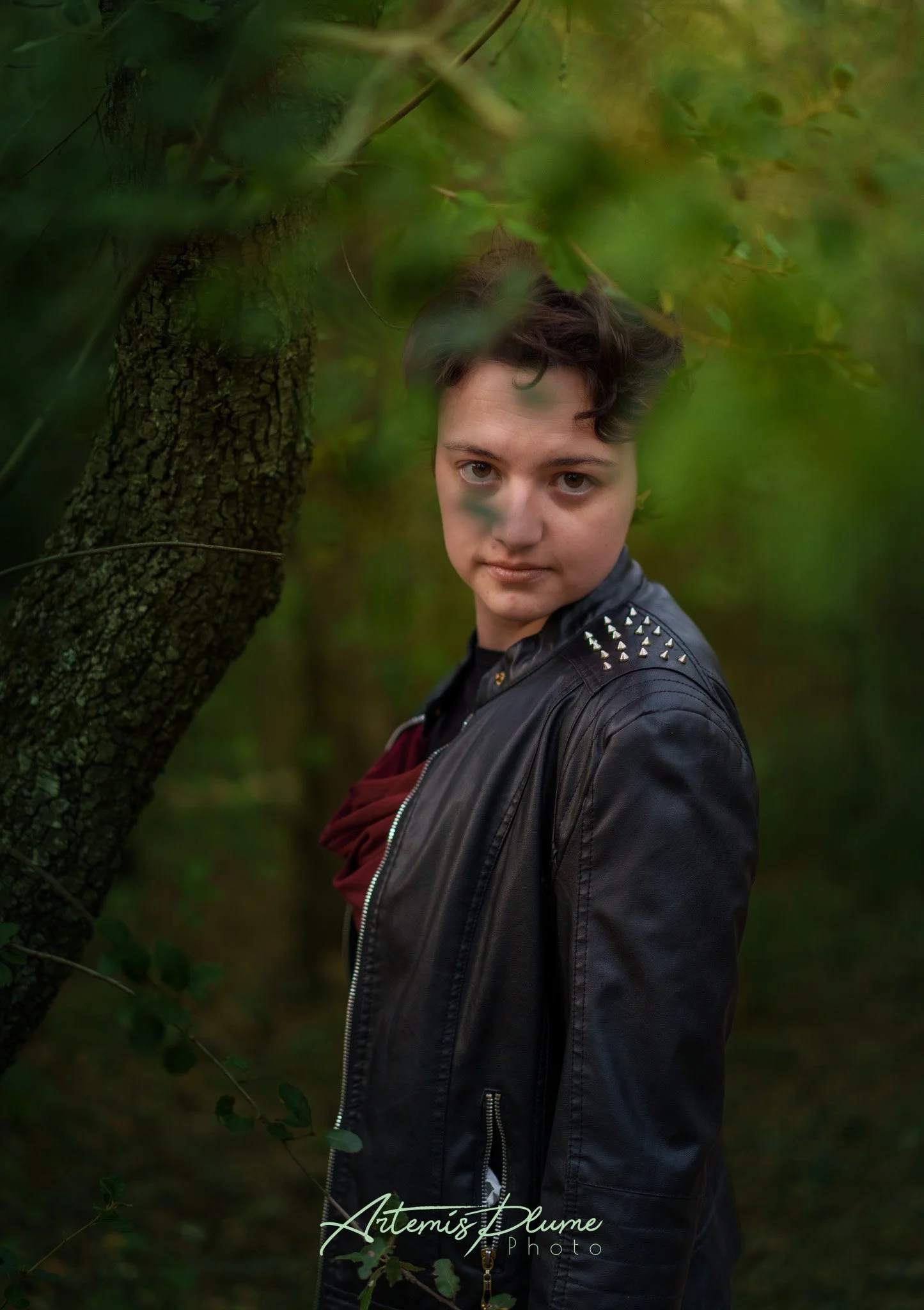 Photo d'une femme avec une veste en cuir dans une forêt