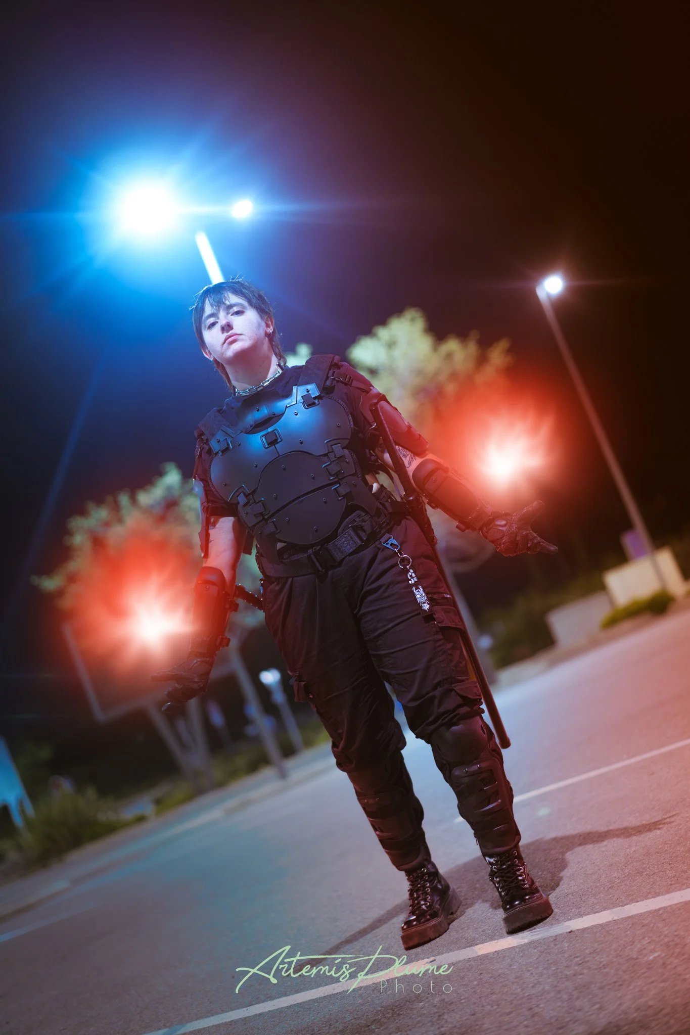 Photo d'une femme en armure moderne sombre, avec des boules d'énergie dans ses mains