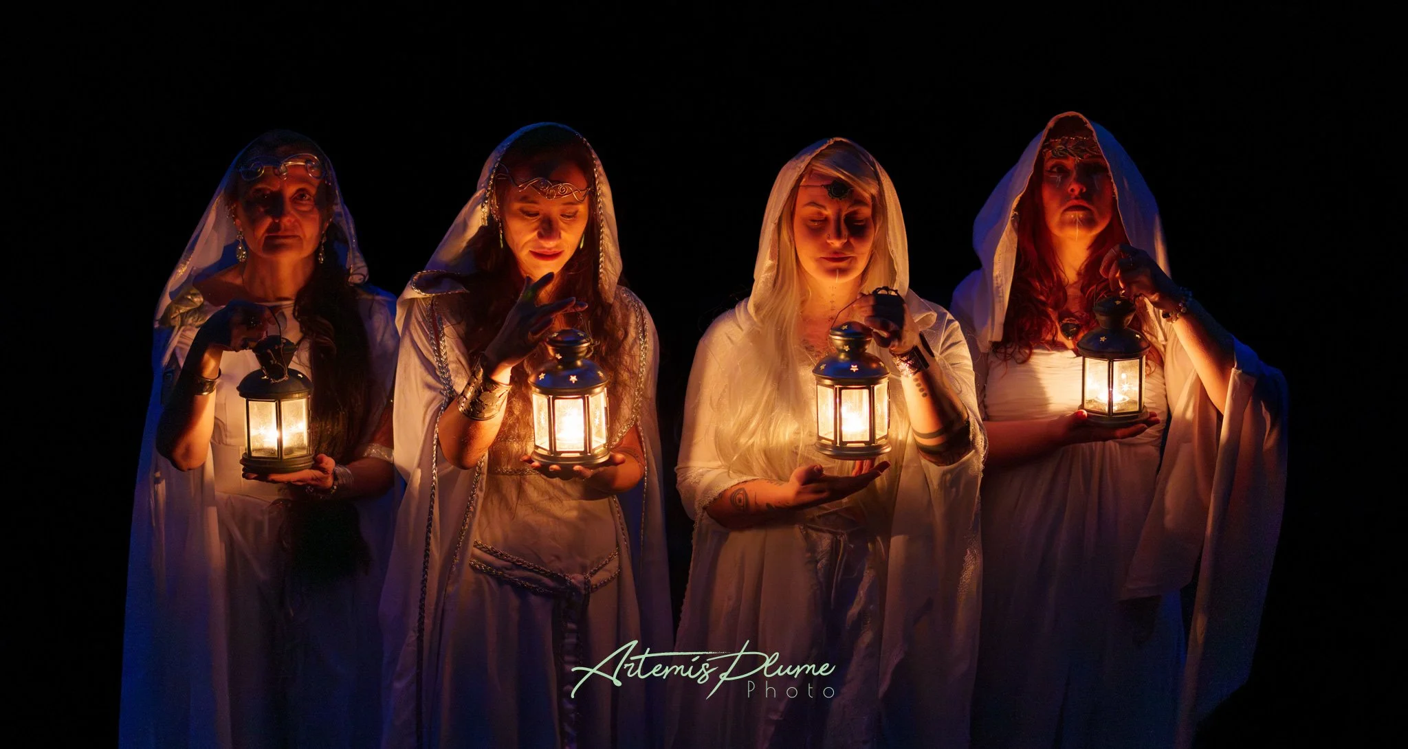 Photo de quatre femmes en costumes d'elfe portant des lanternes