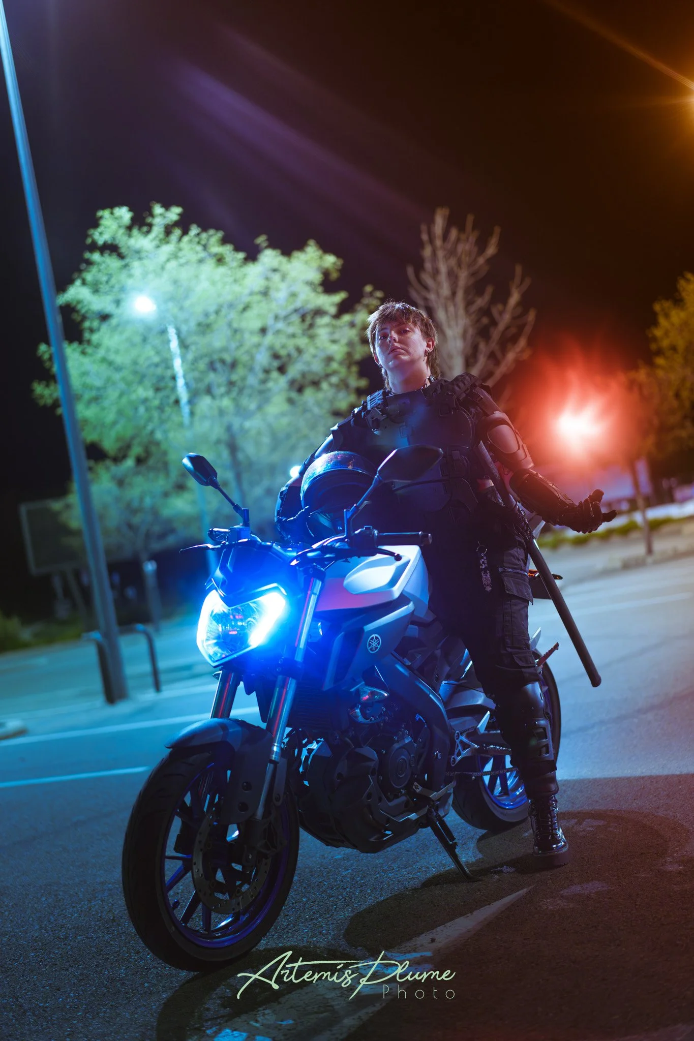Photo d'une femme en armure moderne sombre, sur une moto
