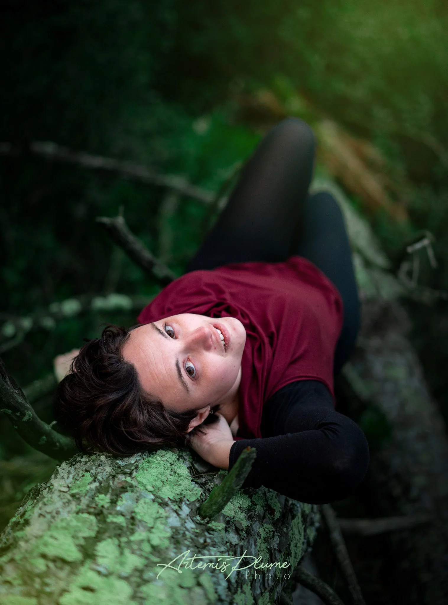 Photo d'une femme allongée sur un tronc d'arbre