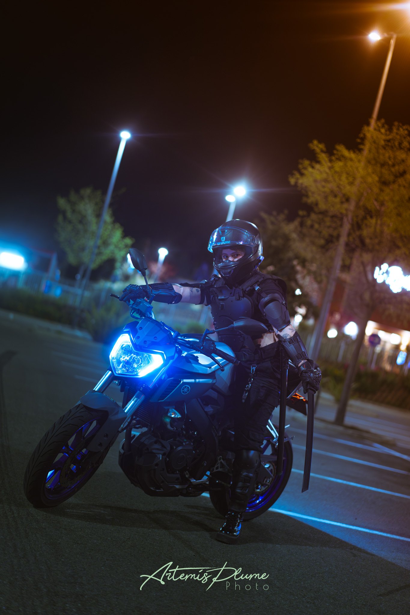 Photo d'une femme en armure moderne sombre, sur une moto