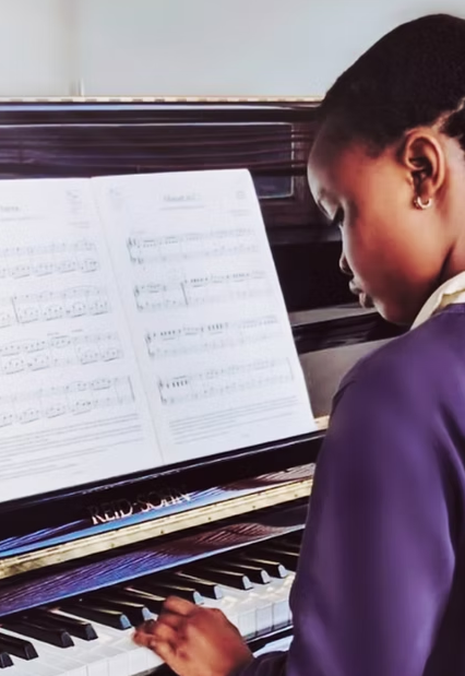 The image shows a child reading music and playing the piano