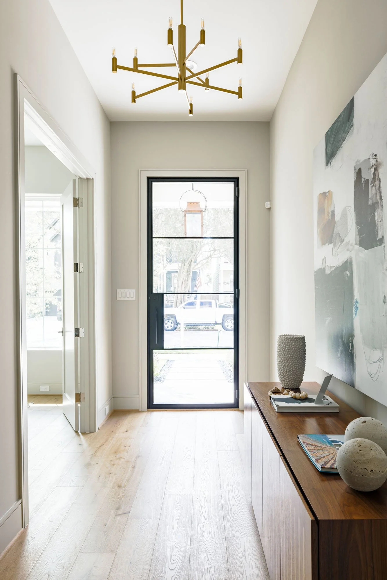 Entryway with full-glass steel front door, copper porch lantern view, and white oak hardwood floors