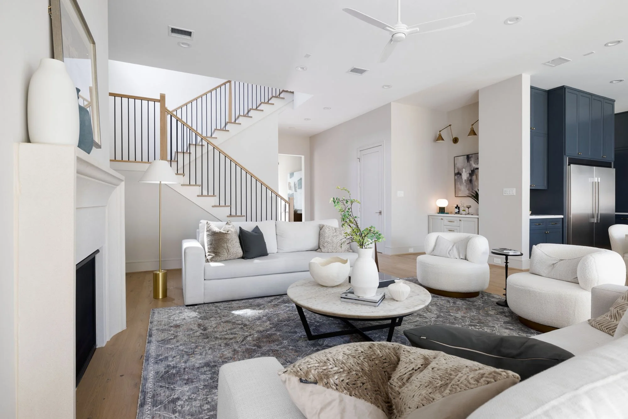 Oak and black iron staircase with tall window and neutral abstract art on the landing
