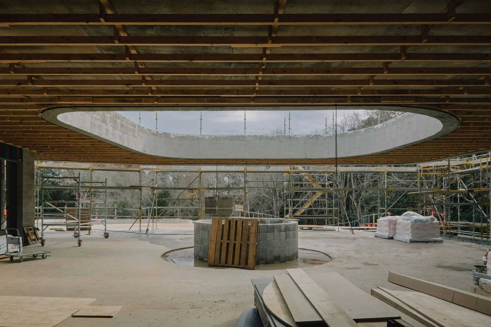 Large residential construction site interior with concrete slabs and curved open details to next floor