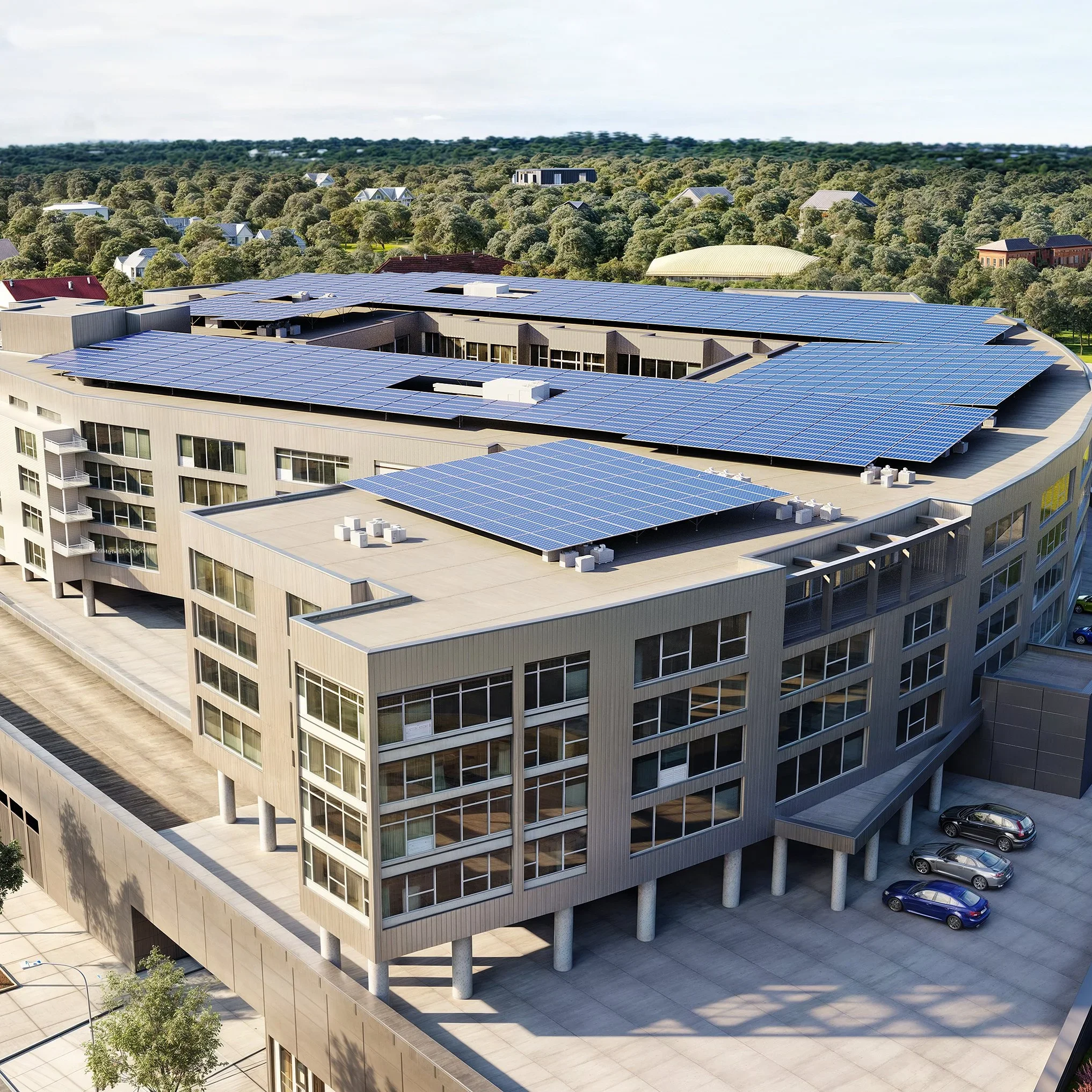 A large modern office building with solar panels on the roof, surrounded by a parking lot with several cars, and a background of trees and houses.
