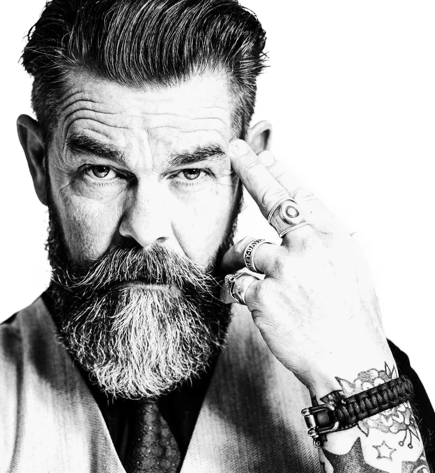 Zwartwit portretfoto van man met baard en tatoages