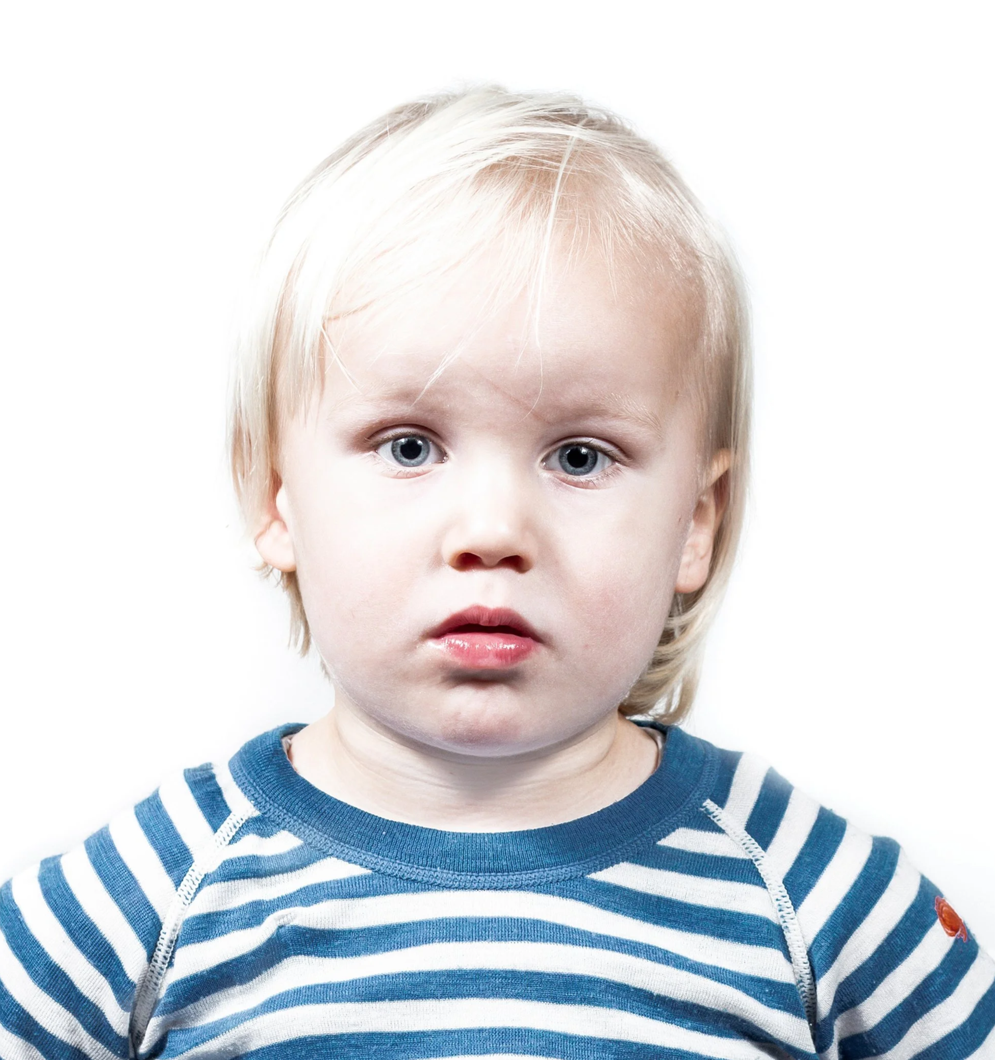 Close-up van een jong kind met blonde haar en blauwe ogen, gekleed in een blauwe en witte gestreepte sweater, tegen een witte achtergrond.