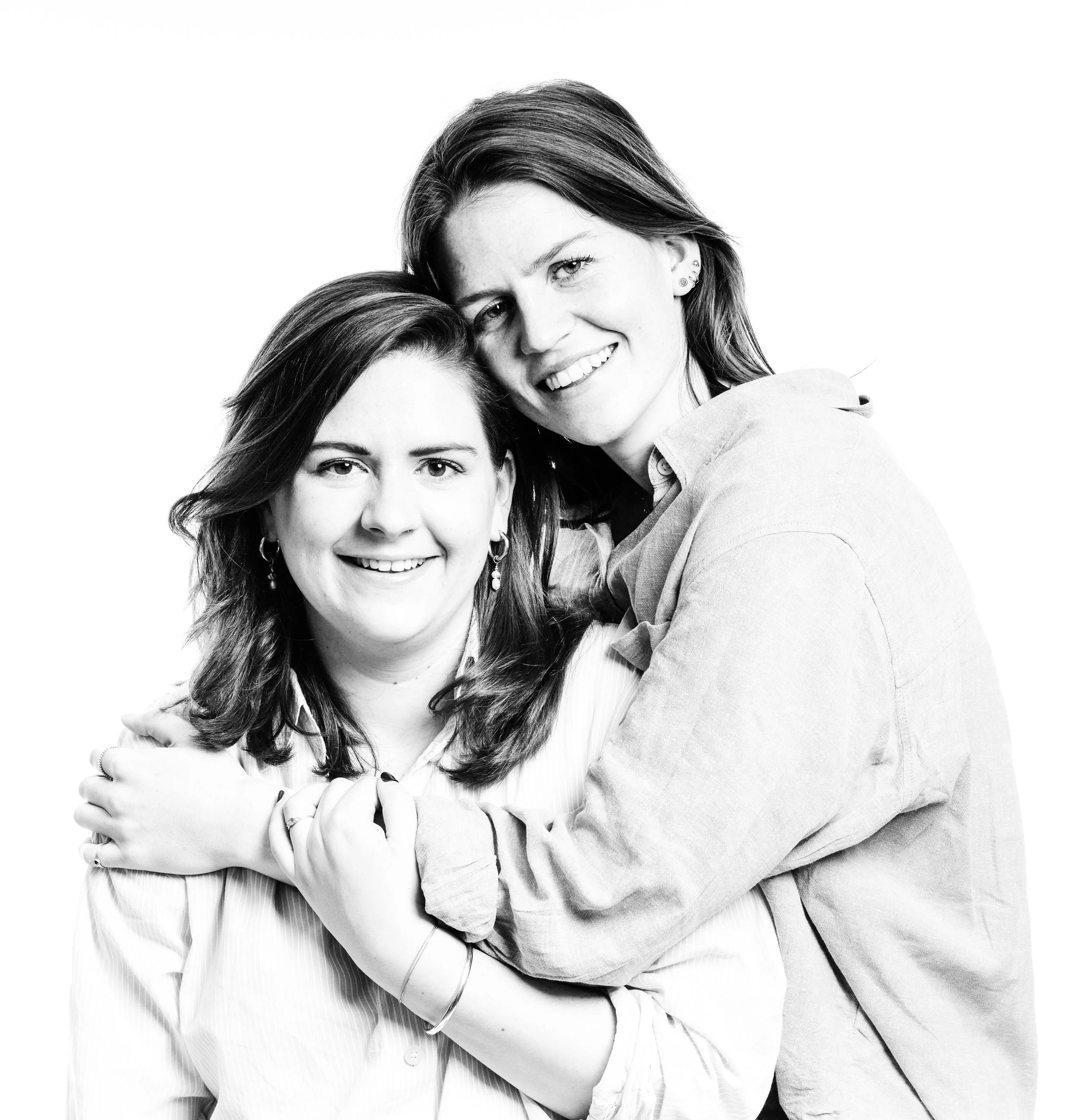 Twee vrouwen knuffelen en lachen, zwart-wit foto, dichtbij