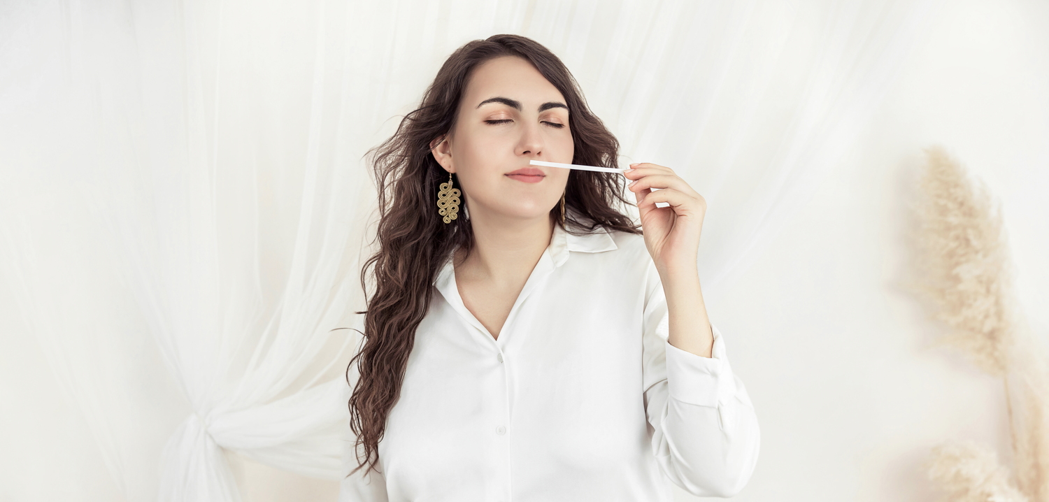 Hungarian perfumer Nyárádi Natália evaluating a bespoke fragrance accord using a scent strip in her atelier.