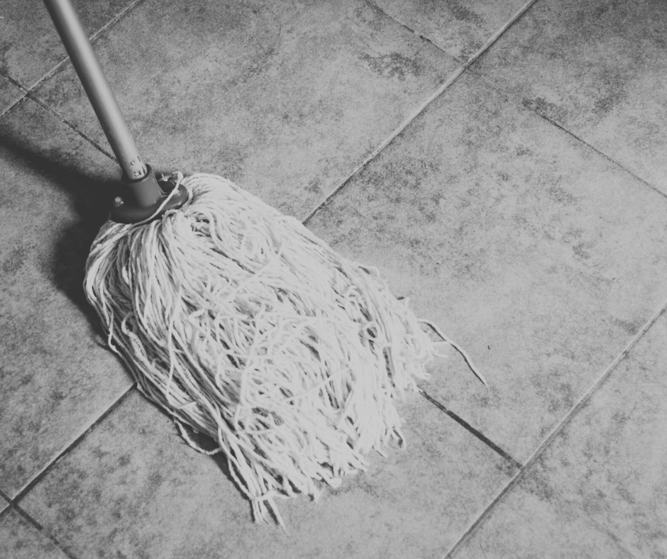 Mop cleaning a tiled floor, representing janitorial services focused on maintaining clean, safe, and professional environments across commercial and public facilities.