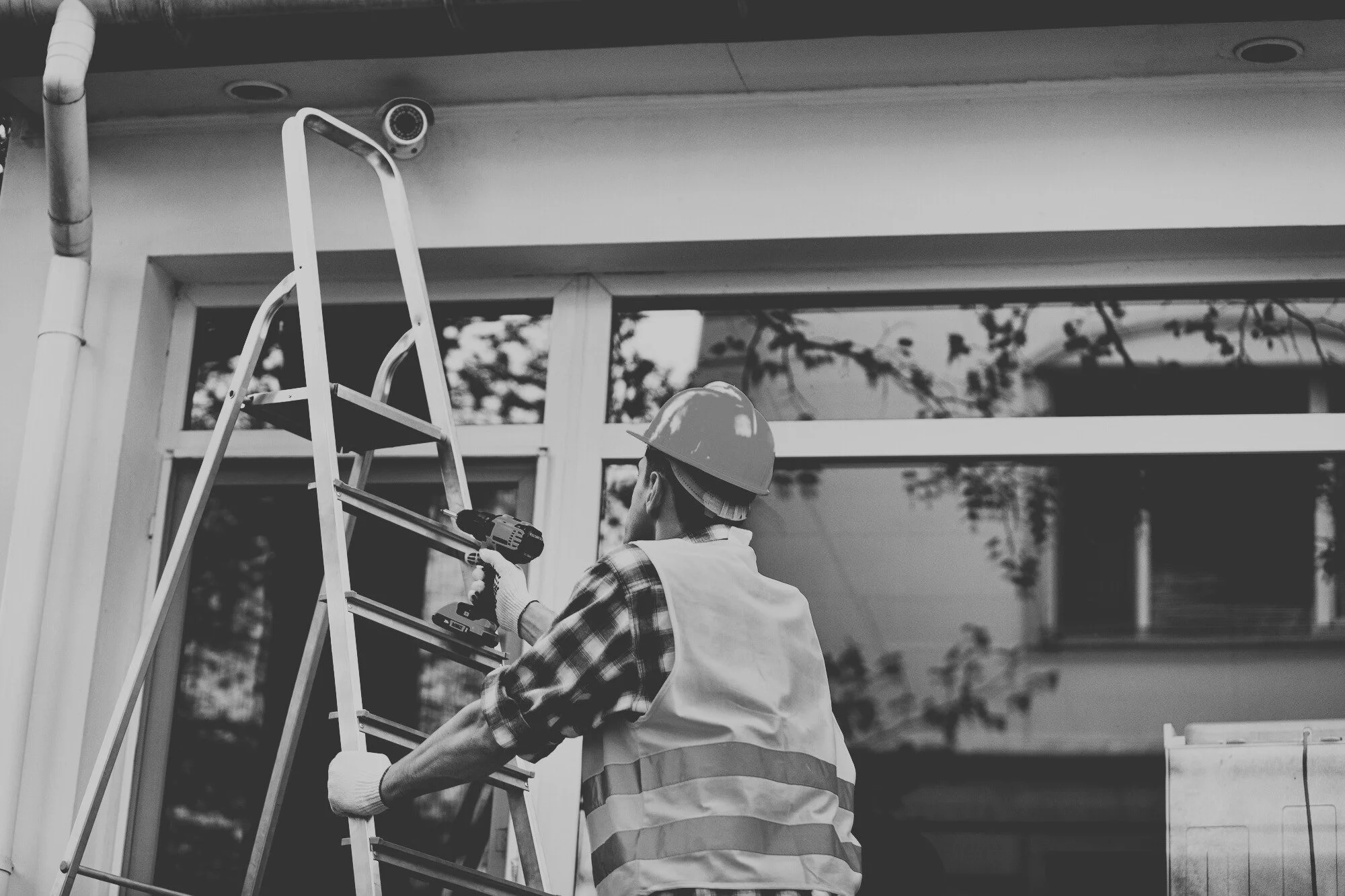 Exterior maintenance services in progress with technician performing routine building inspections and repairs