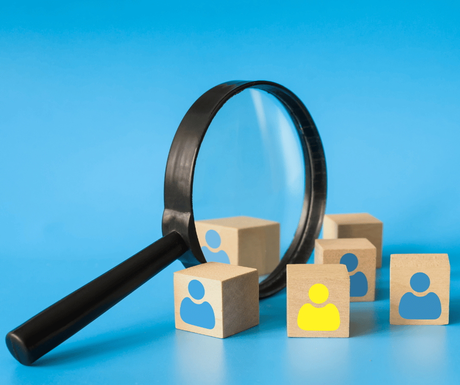 Lente di ingrandimento su blocchi di legno con icone di persone, concetto di selezione del personale e recruiting