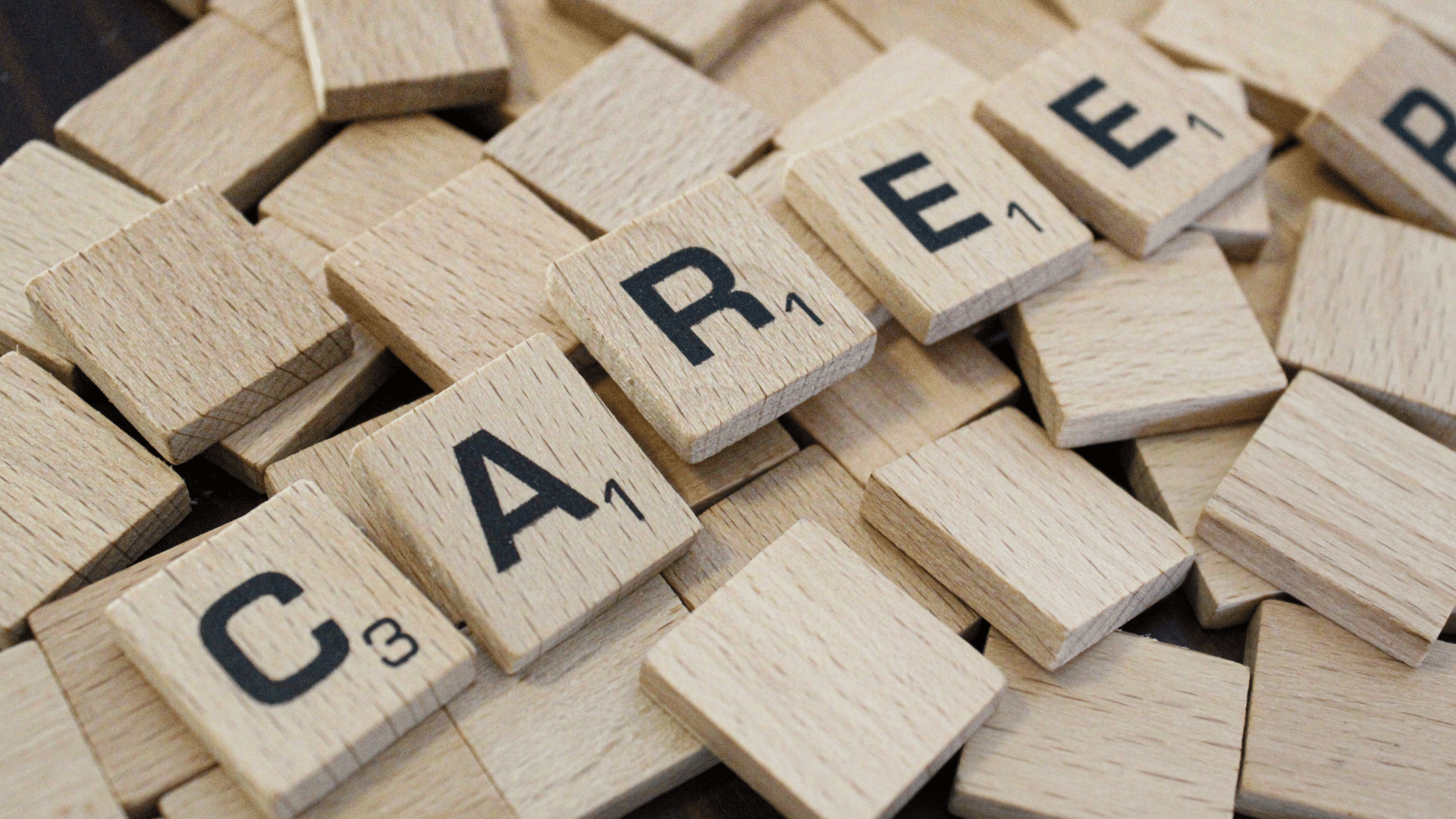 Tessere di legno tipo scrabble che formano la parola Career, simbolo di crescita professionale e carriera lavorativa.