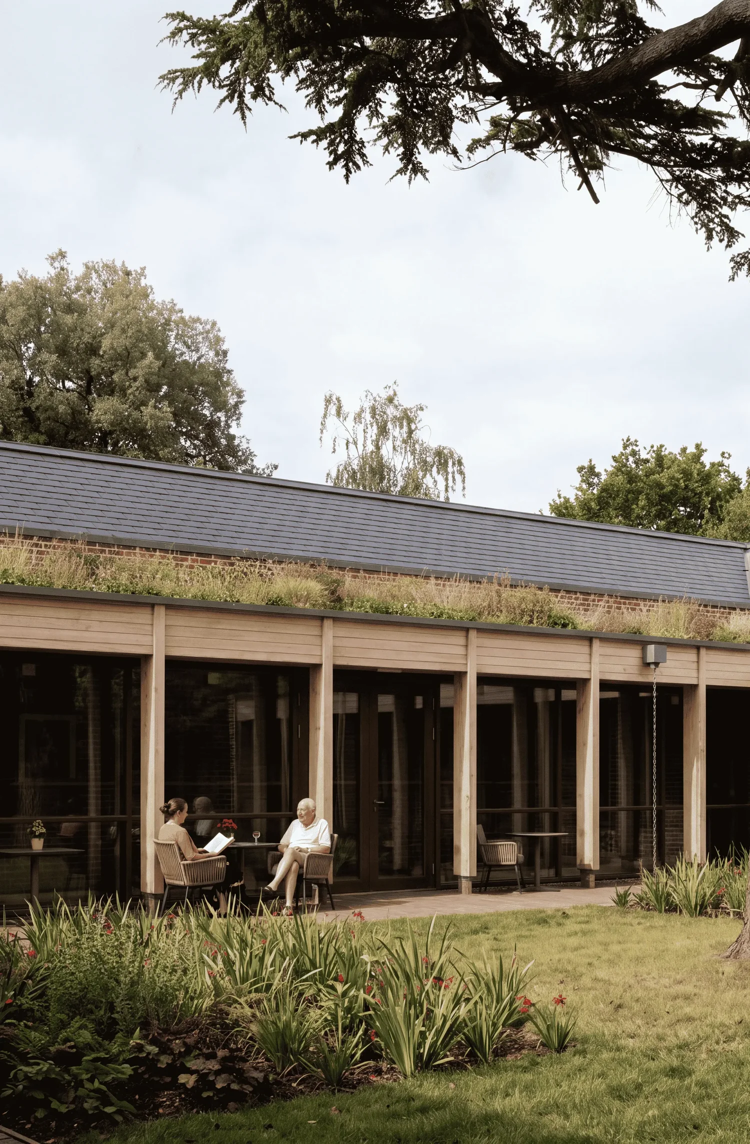 Design visualisation of the Toby Inn mixed-use care home, with a timber colonnade, green roof and residents in the garden, designed by Studio 9 Architecture