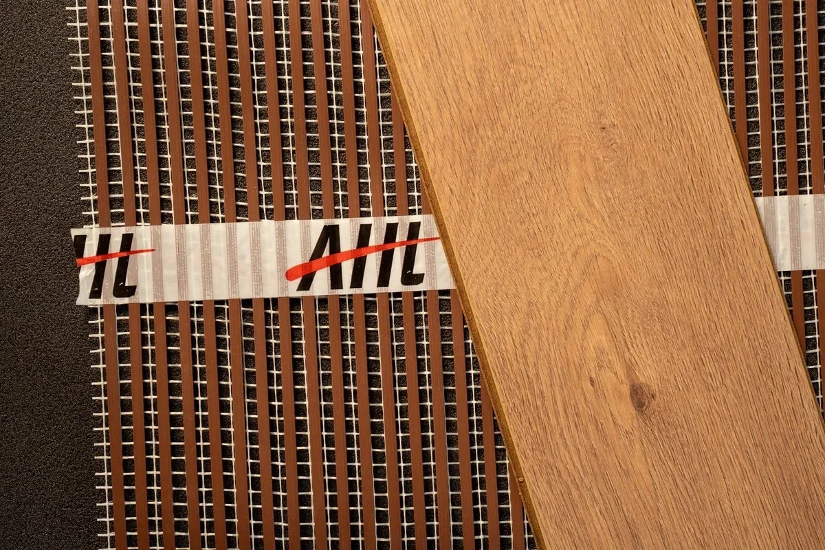 Wood-effect flooring sample alongside ribbon heating.