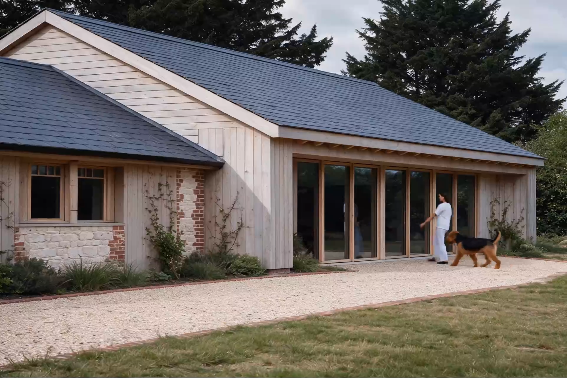 Single-storey timber-clad extension with a slate roof and full-height glazing, Montford, Pendle