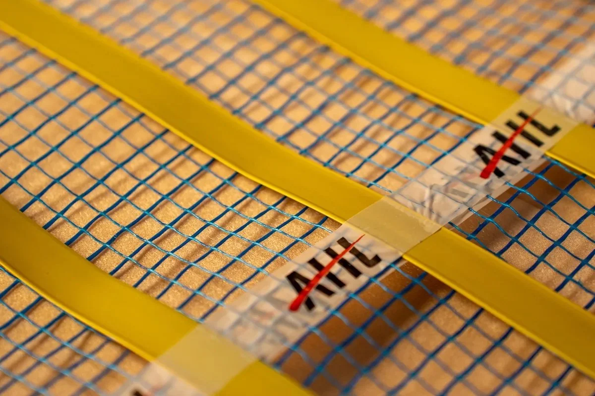 Close-up of ribbon heating strips on blue mesh.