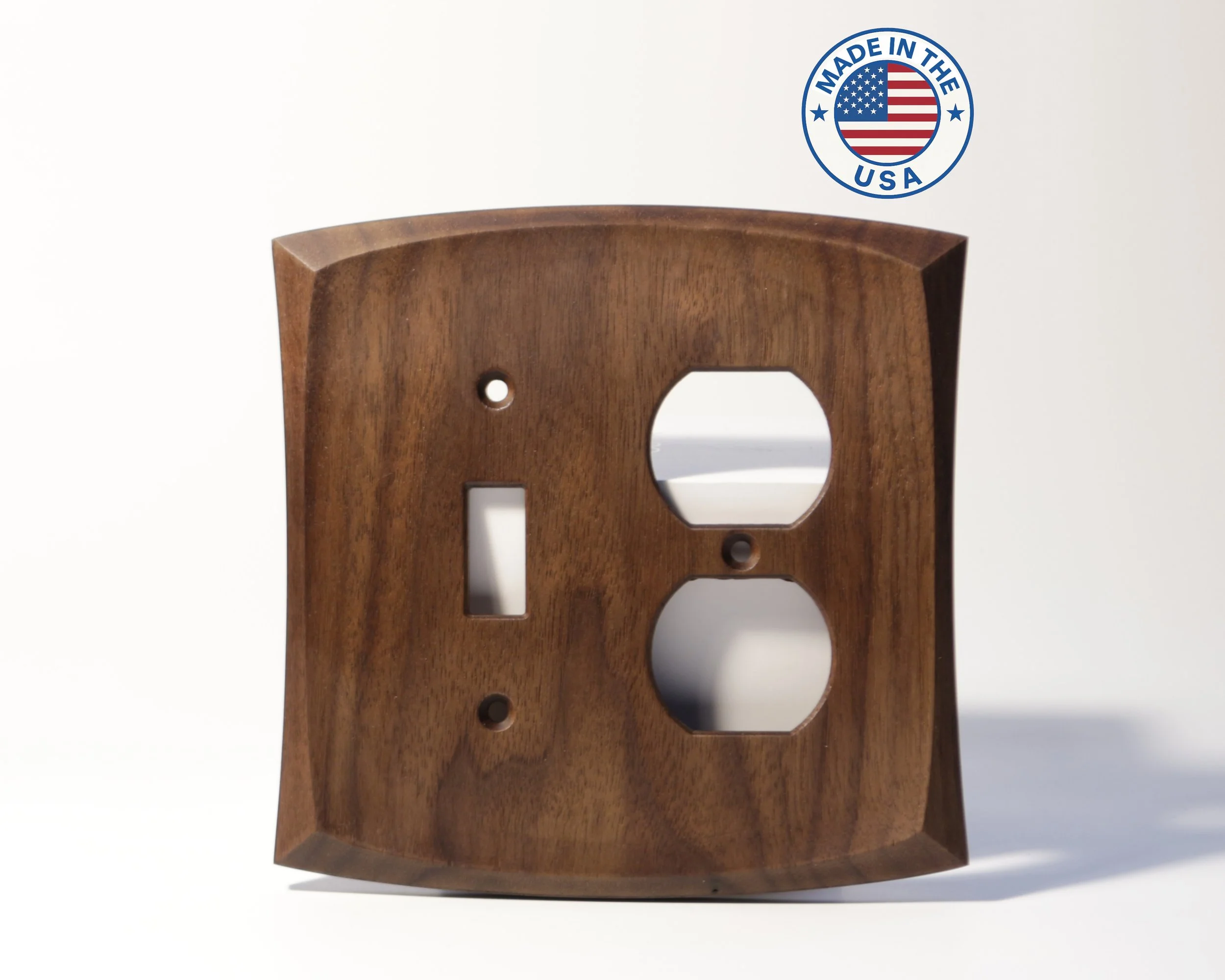 A wooden wall plate with cutouts for electrical outlets and switches, positioned vertically, with a "Made in the USA" sticker featuring the American flag on a white background.