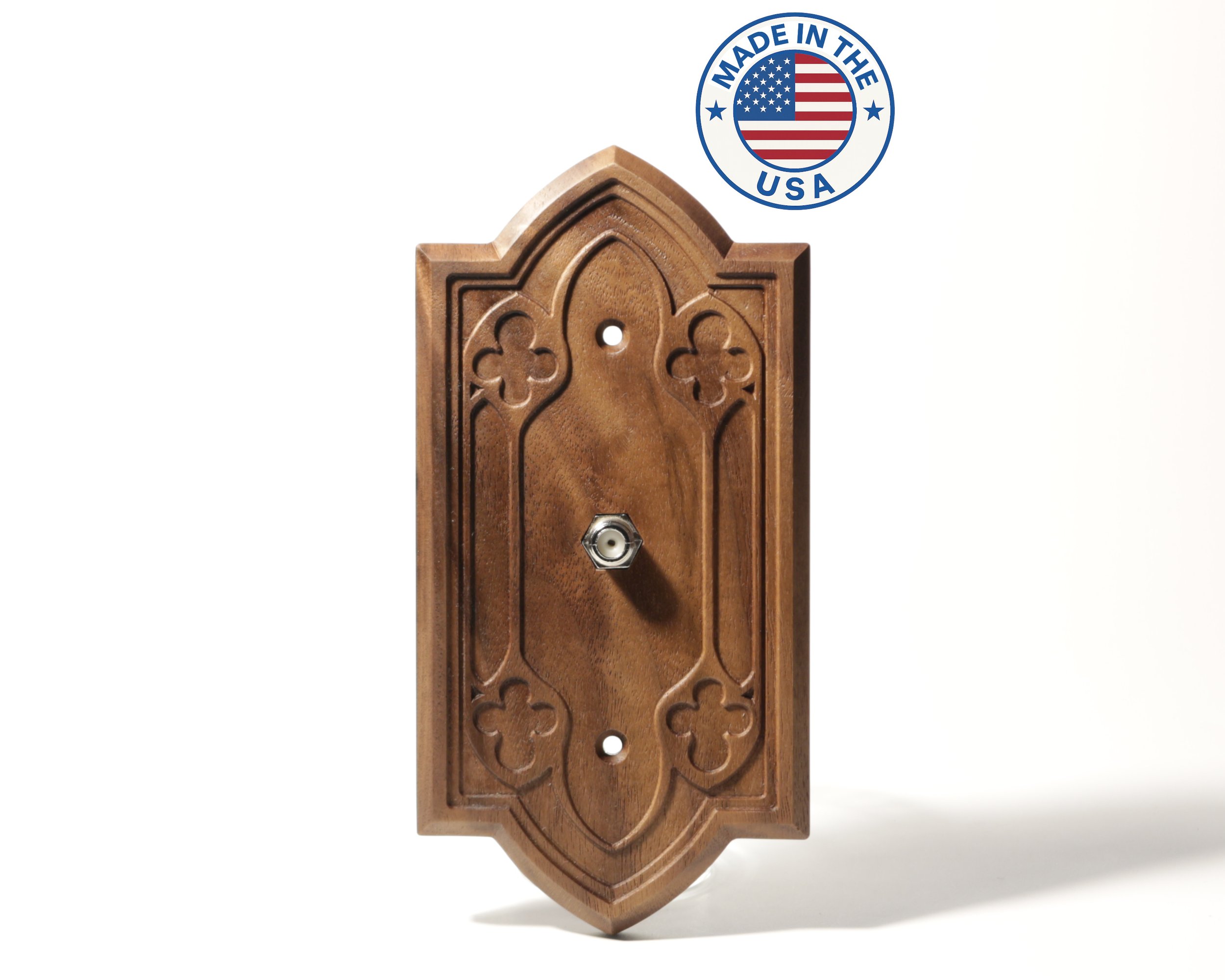 A wooden wall-mounted decorative piece with laser-cut floral and geometric patterns, and a hole for mounting. In the upper right corner, a blue circular seal with a US flag and the words "Made in the USA."