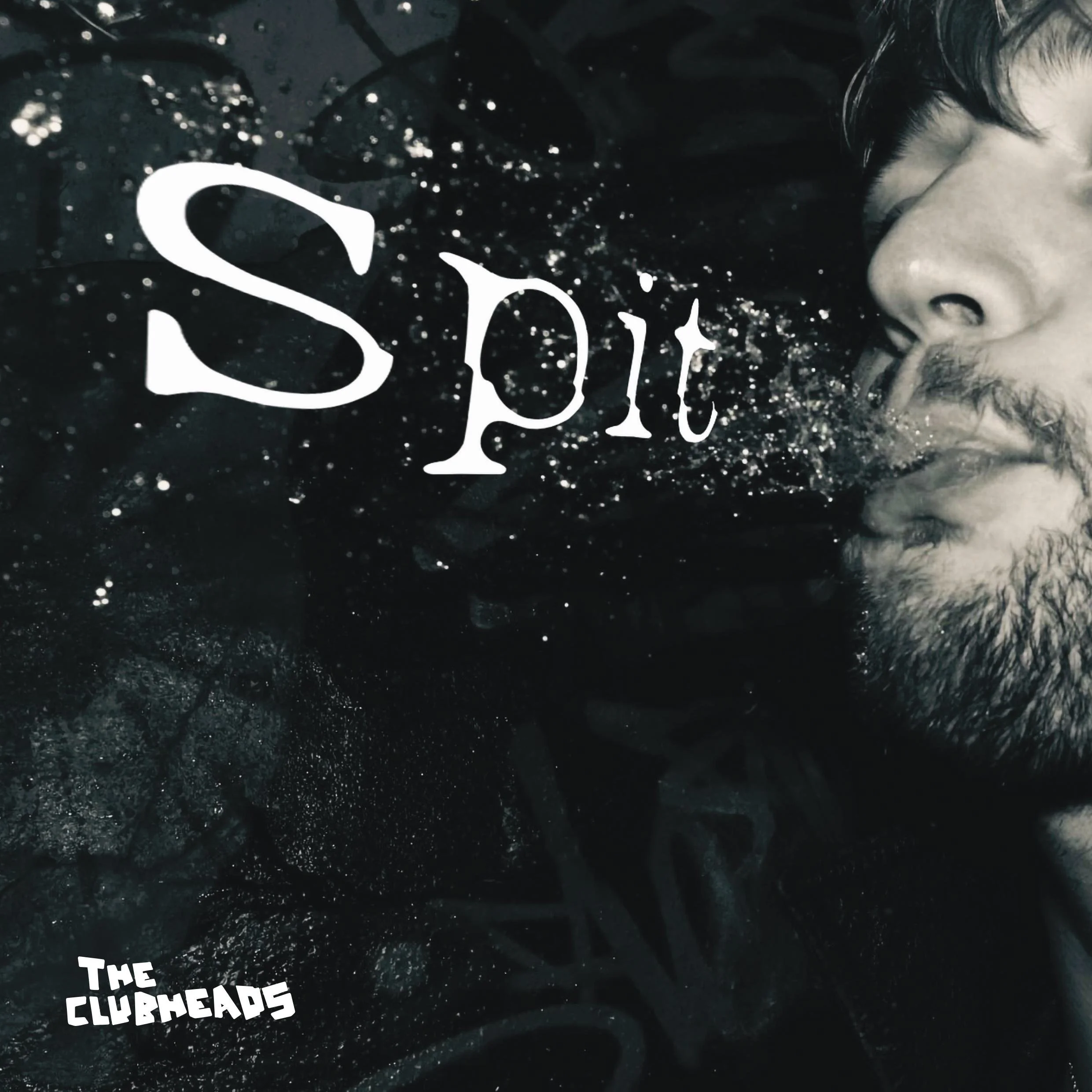 A black and white photo of a man's face in profile with a beard and closed eyes, positioned on the right side of the image. The word 'Spirit' is written across the image in large, white, stylized text. The phrase 'The Clubheads' appears in smaller, white text in the lower left corner. The background contains abstract dark textures with speckles of light and a sense of motion.