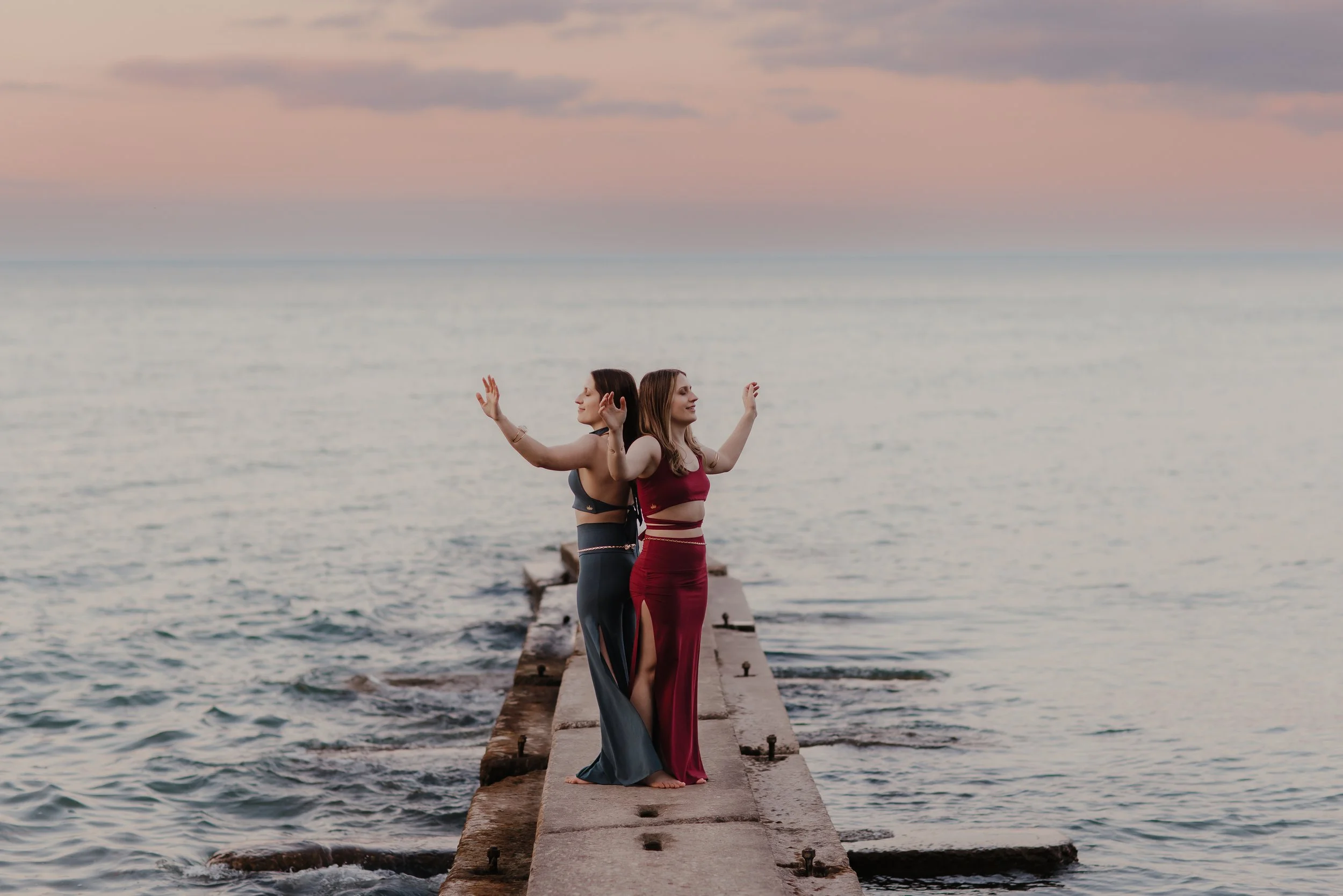 Marley and Lacey stand back to back with their arms outstretched.