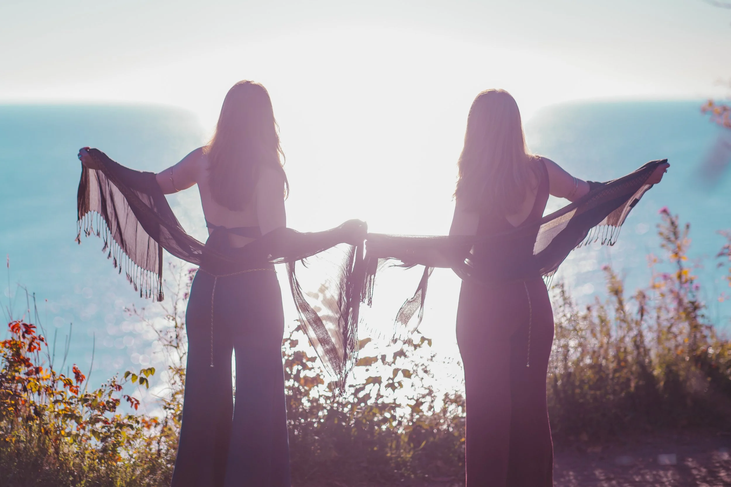Marley and Lacey stand on a bluff side overlooking a lake.
