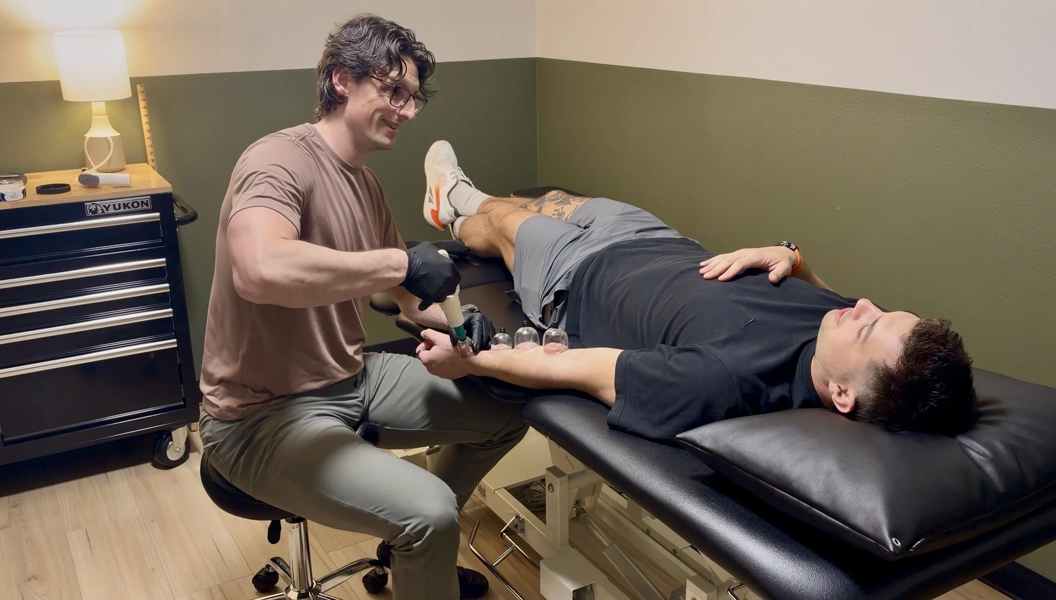 Dr. Ryan Eckert performing MFD cupping on patient forearm post wrist fracture.