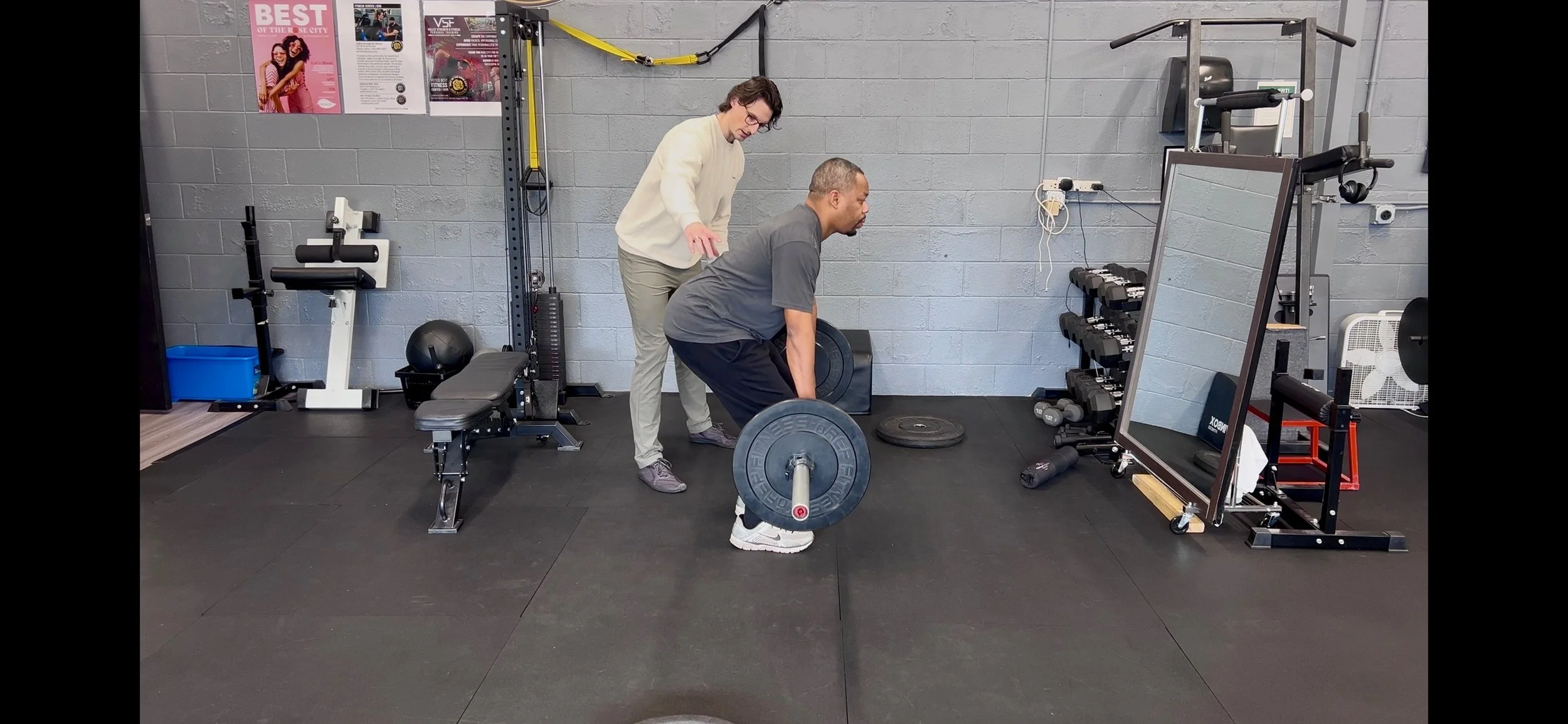 Dr. Ryan Eckert helping with deadlift form for low back pain.