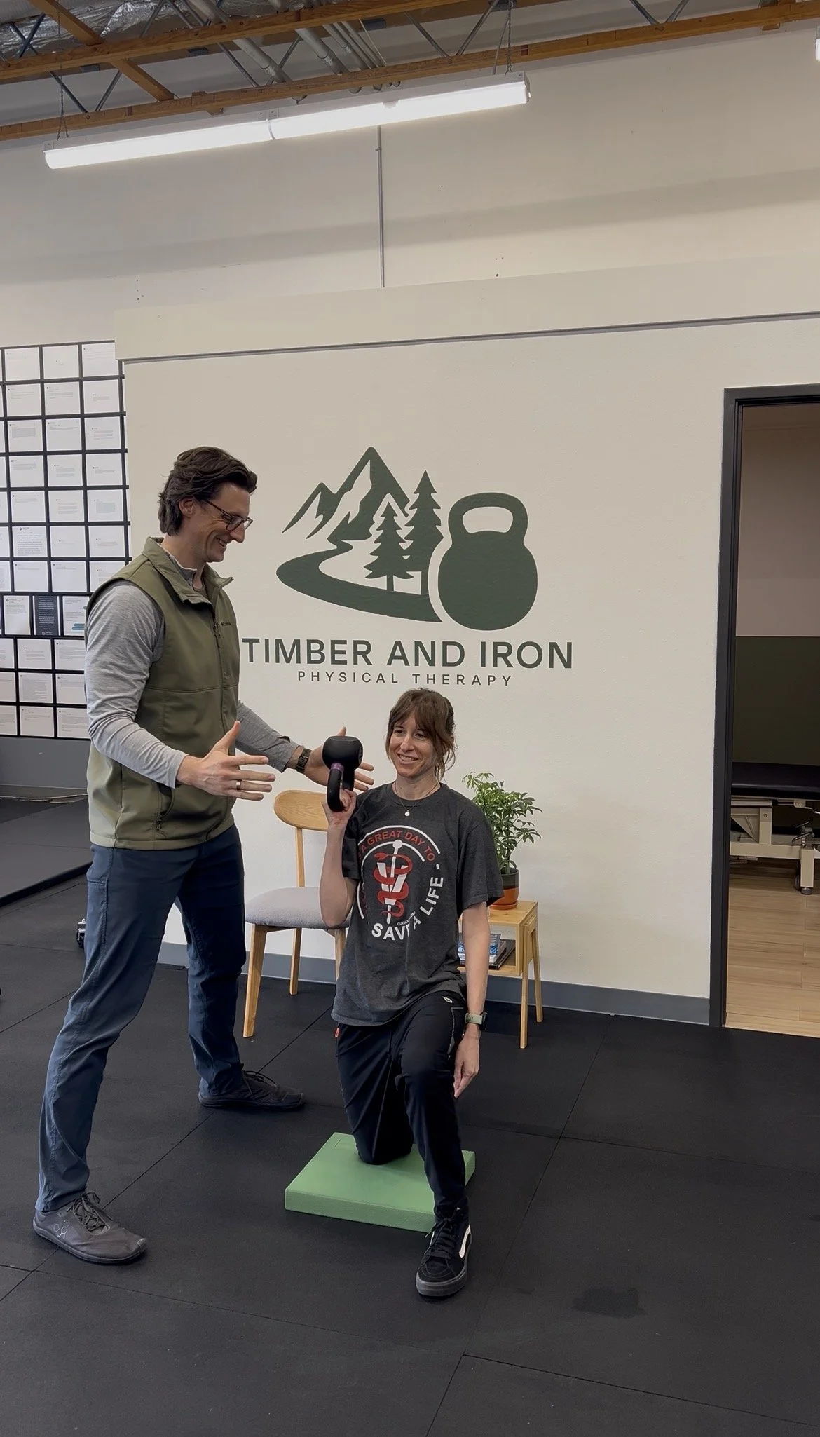 Dr. Ryan Eckert supporting a patient with an overhead press