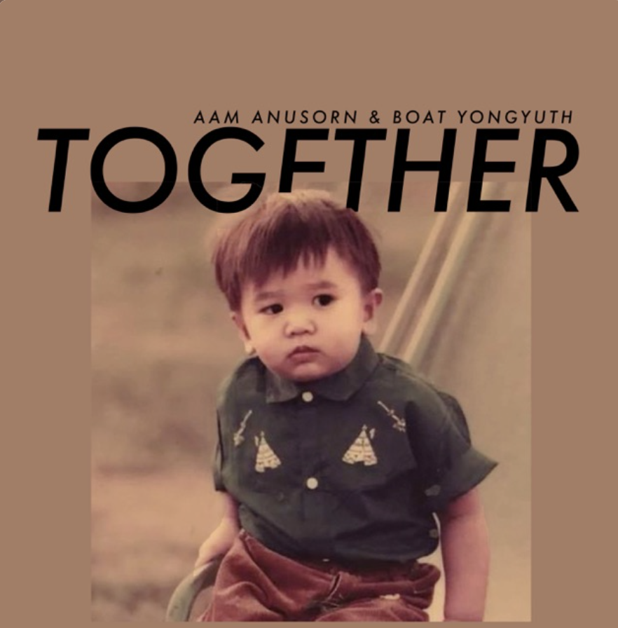 A young boy with brown hair wearing a dark green shirt with a pattern and red pants, standing outdoors with a neutral expression.